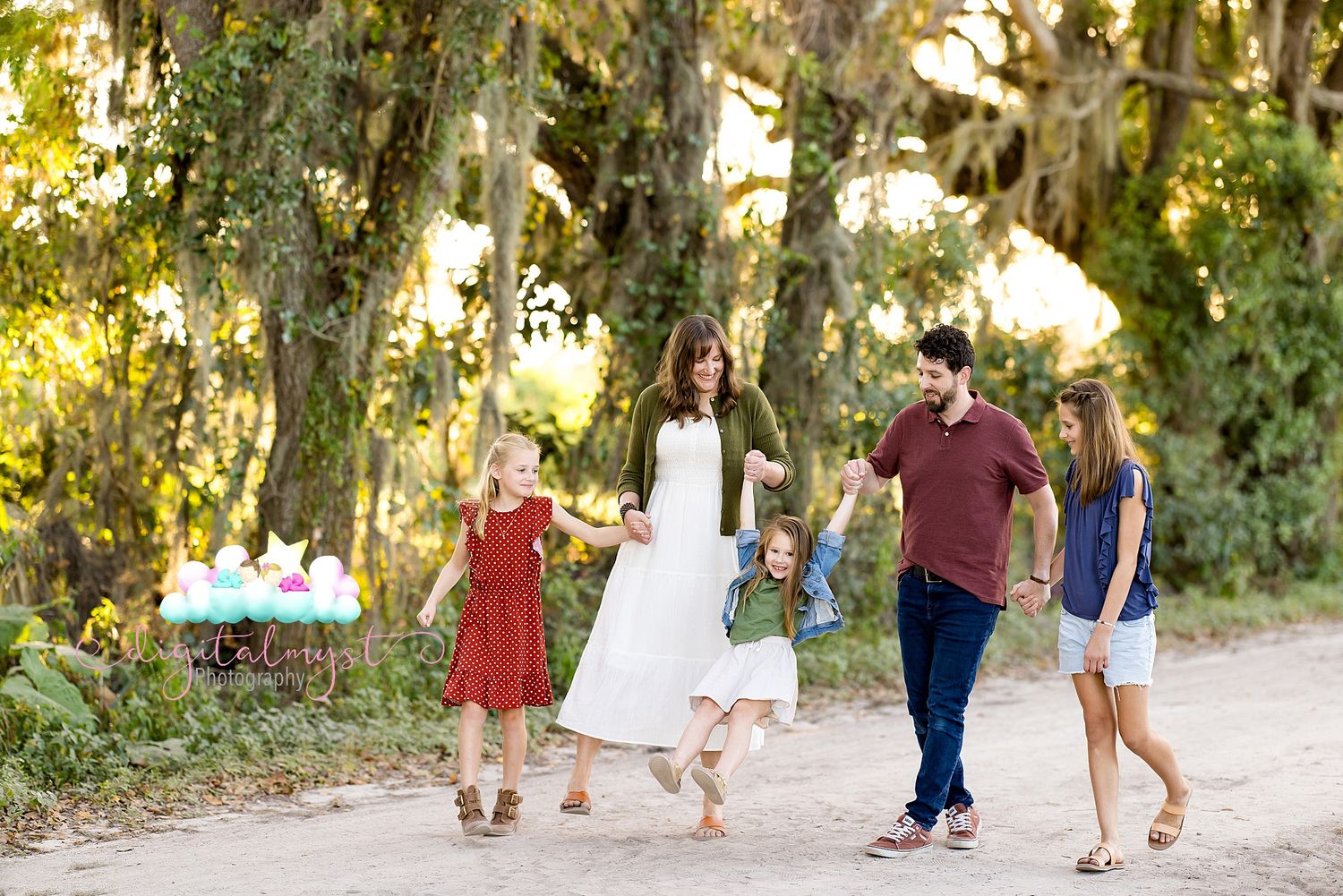 People walking together on a tree-lined path during golden hour with sunlight filtering through the leaves.