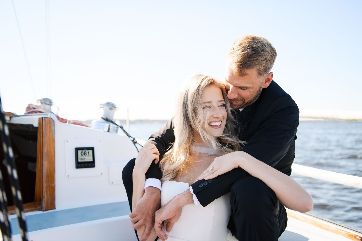 Romantic couple embraces on a seaside balcony during sunset while sharing intimate moments together.
