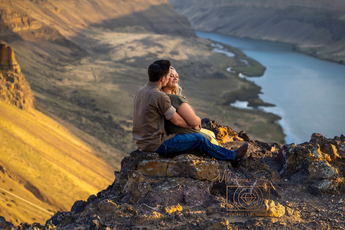 swam falls dam with golden glow of sun on faces of engaged couple