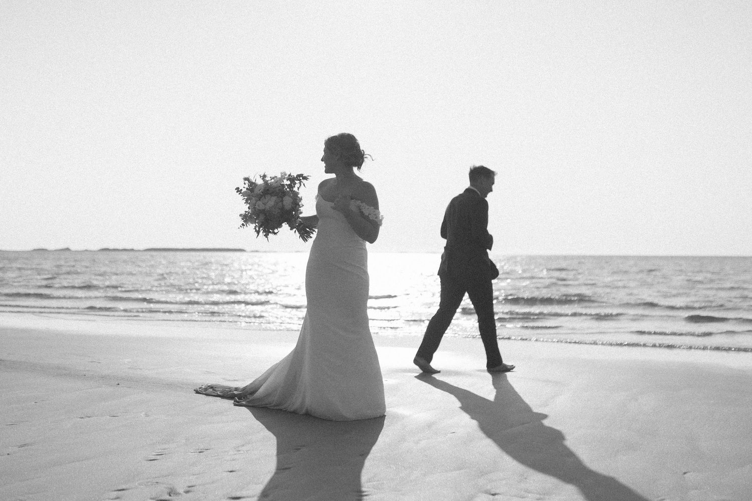 bride and groom run and laugh through the shallow waves at their Tofino Elopement