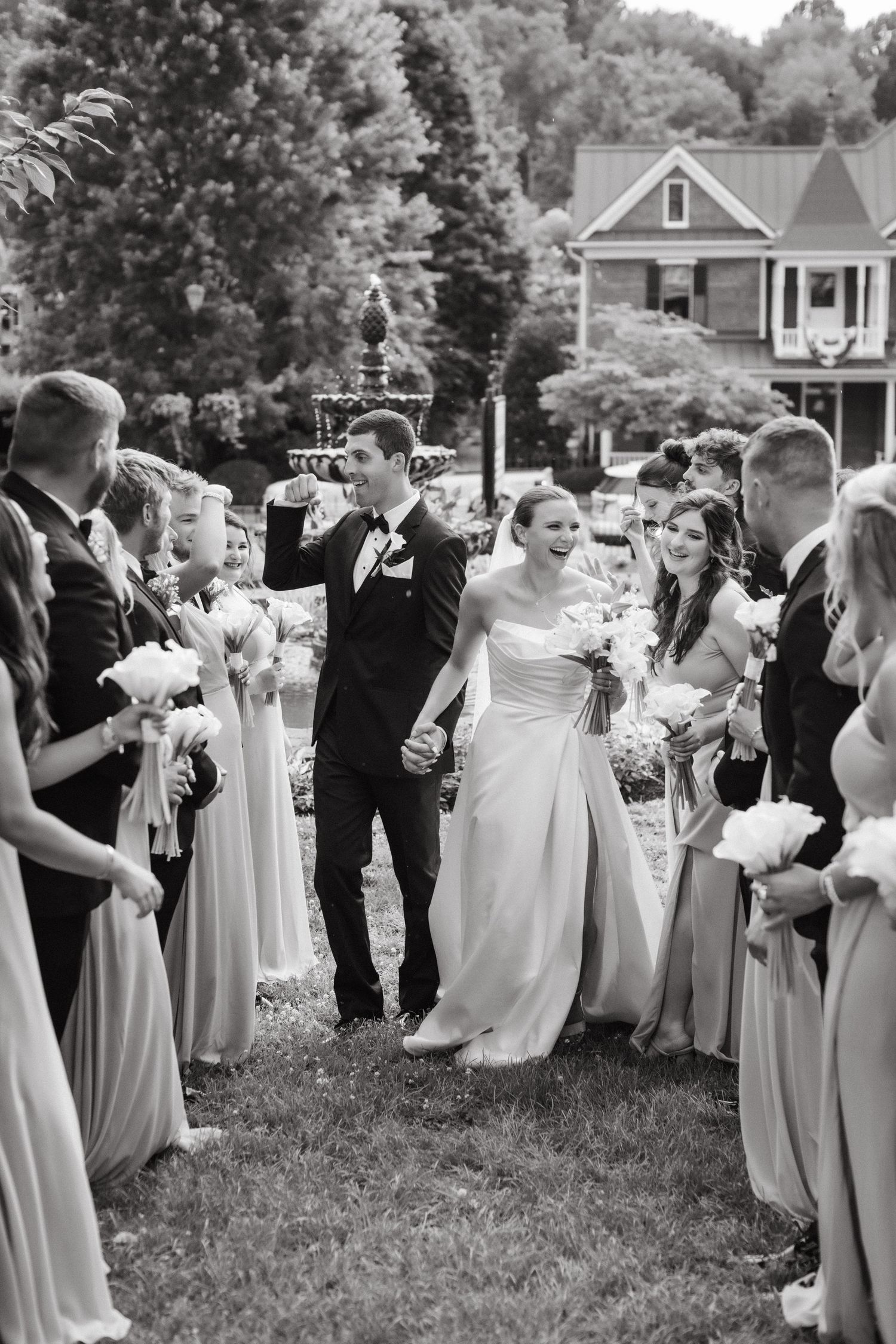 Wedding party celebrates outdoors with champagne toasts and laughter on a sunny day.