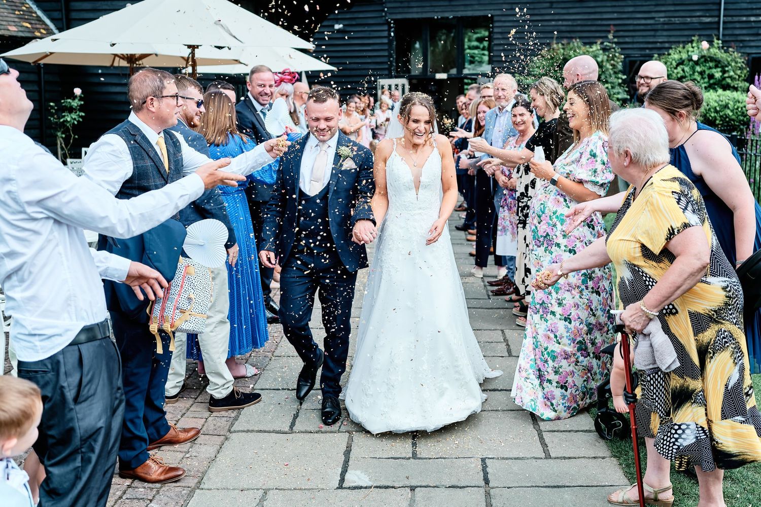 Wedding guests dance and celebrate on an outdoor patio during a lively reception party at Winters Barns