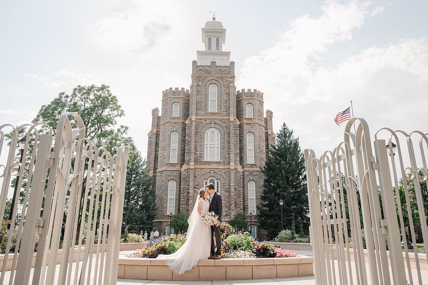 A grand historic church building with ornate architecture and white gates in the foreground.