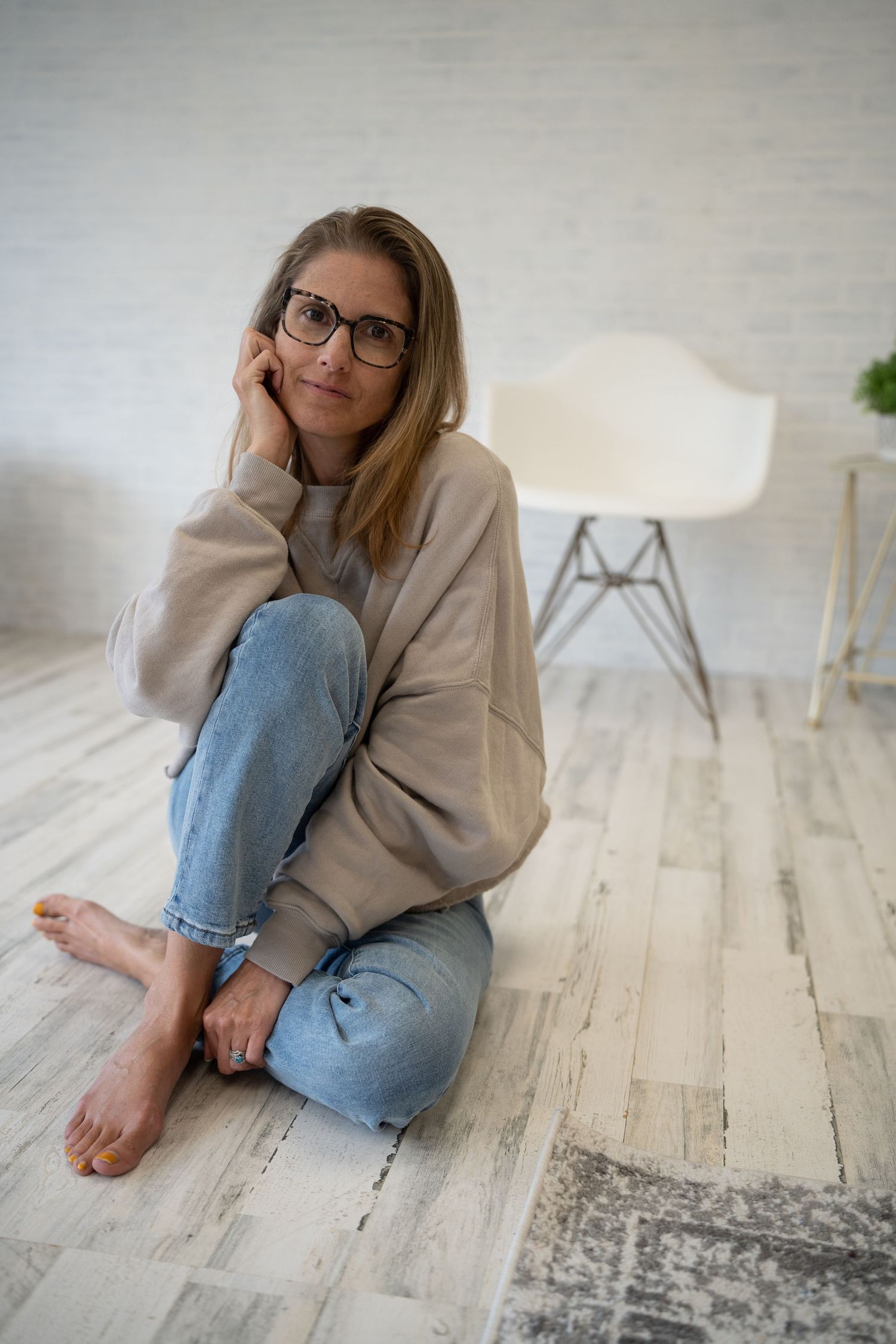 Casual lifestyle photo with cozy cream sweater and jeans on rustic wooden floor.