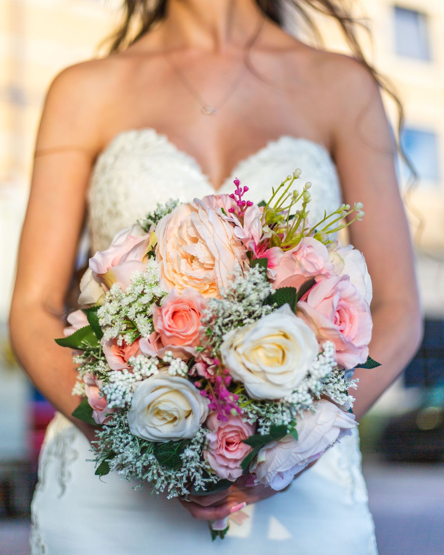 Beautiful bridal bouquet with pink and white roses, baby's breath and mixed florals.