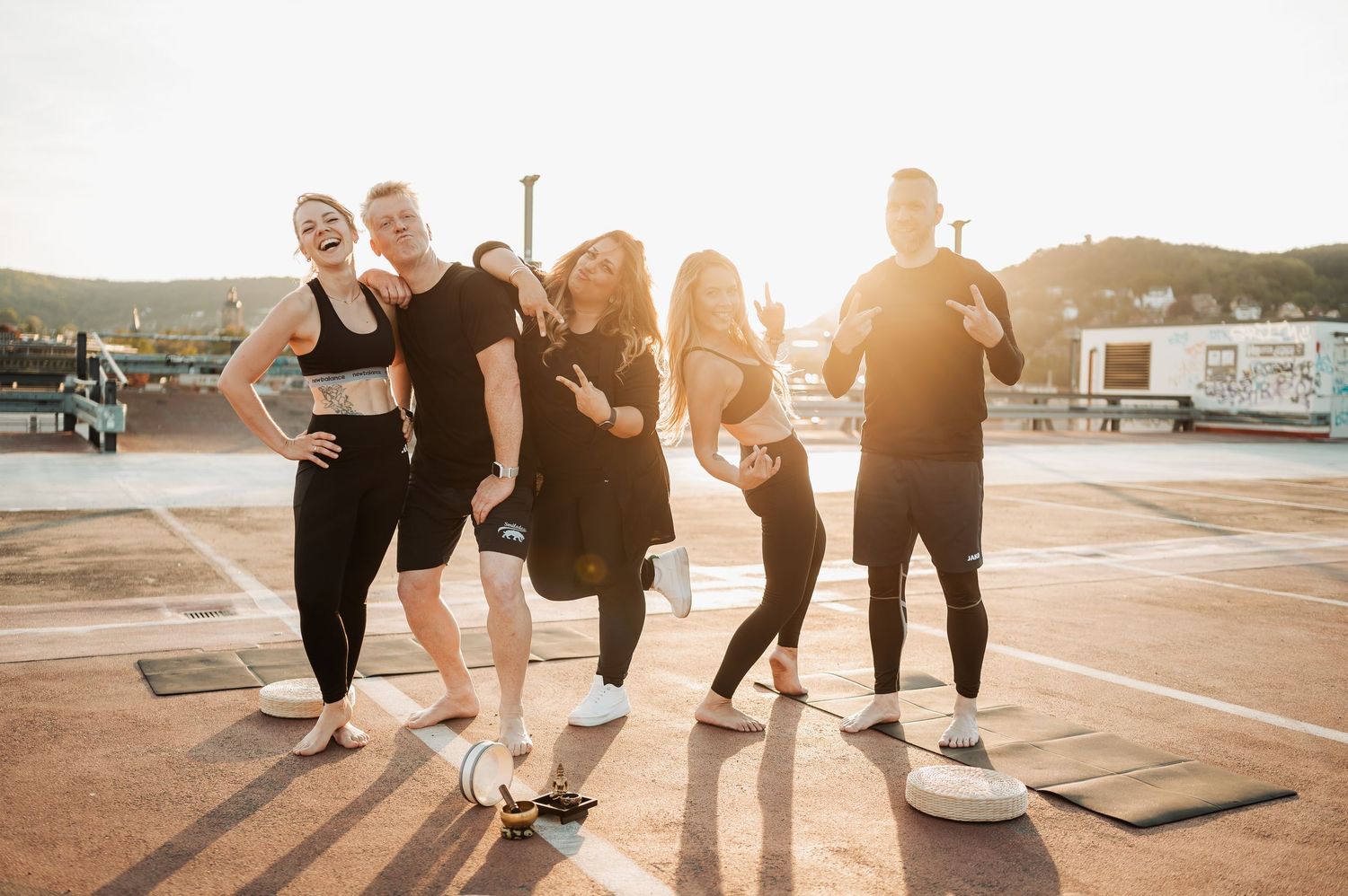 Group of people walking together on a paved surface during golden hour sunset with lens flare effect.