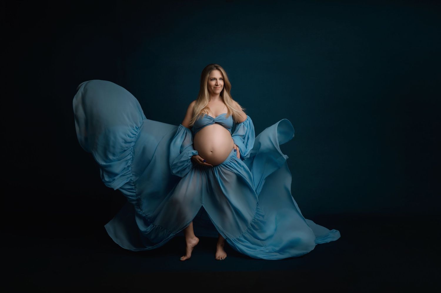 A series of flowing blue fabric photos shows graceful movement and feminine silhouettes against a dark background.
