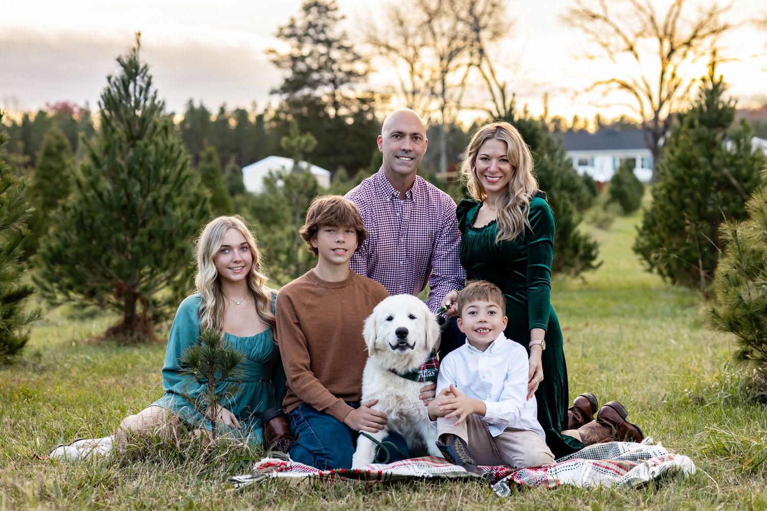 A family enjoys quality time together in an outdoor photo session at a Christmas tree farm during sunset. RVA, Richmond, Virginia