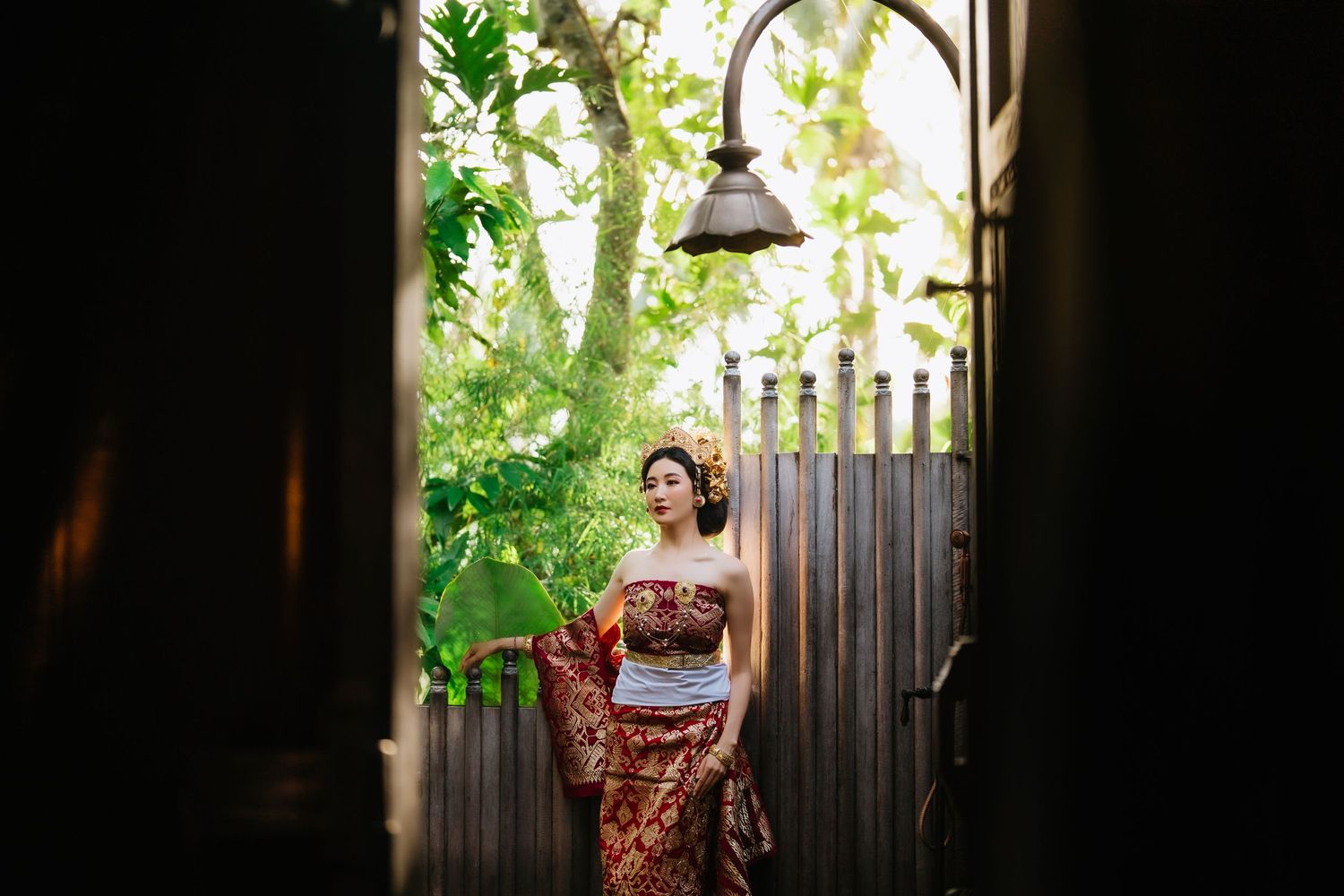 Silhouetted figure in traditional dress framed by doorway in natural lighting.