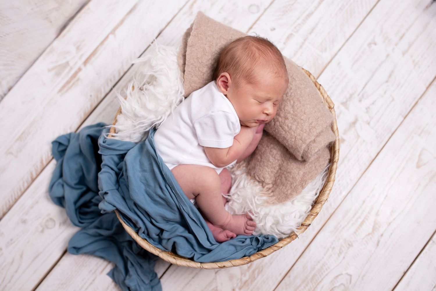 newborn baby posed in basket by little wonderland photography widnes cheshire