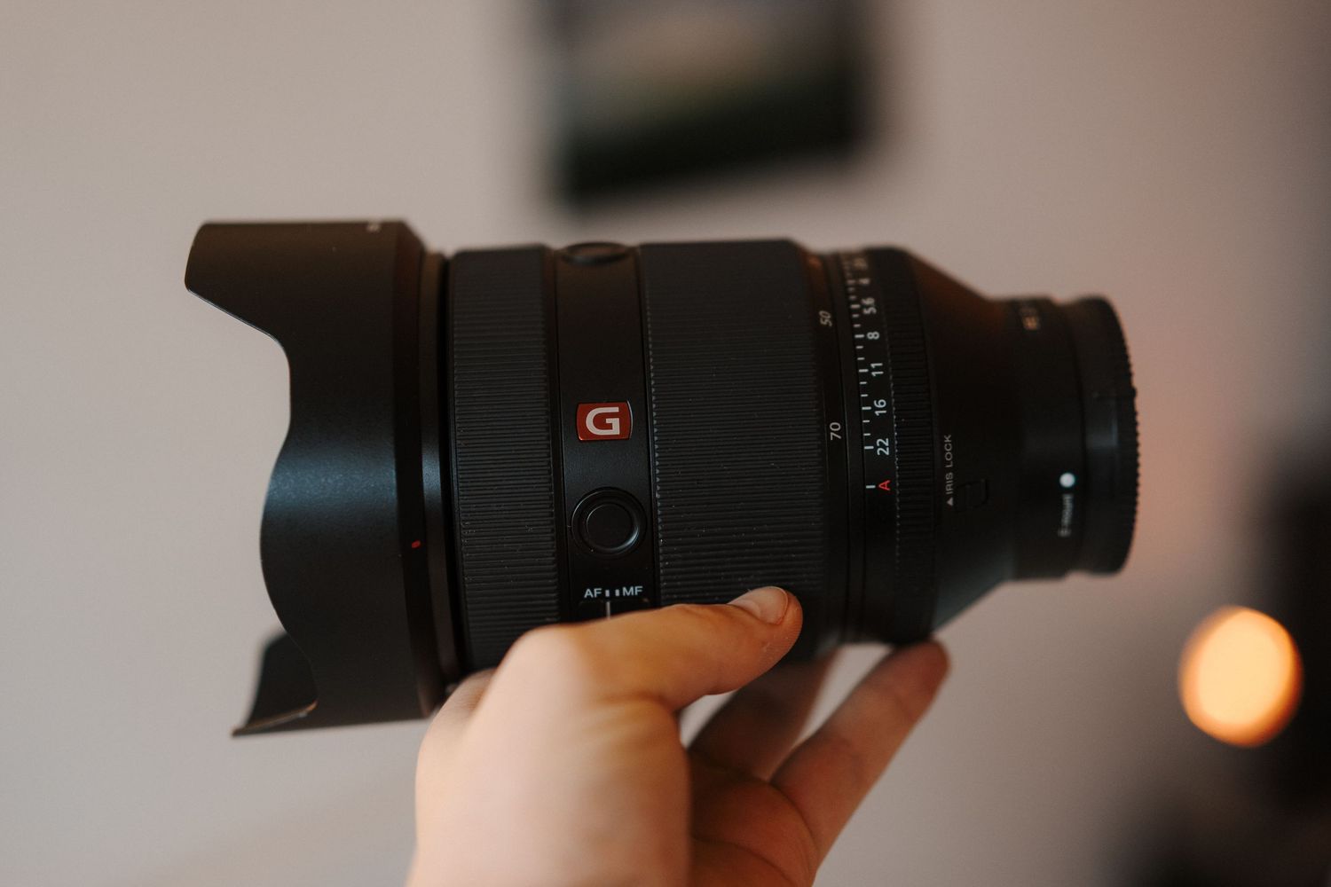 Professional camera lens collection displayed on wooden surface with blue accent lighting.