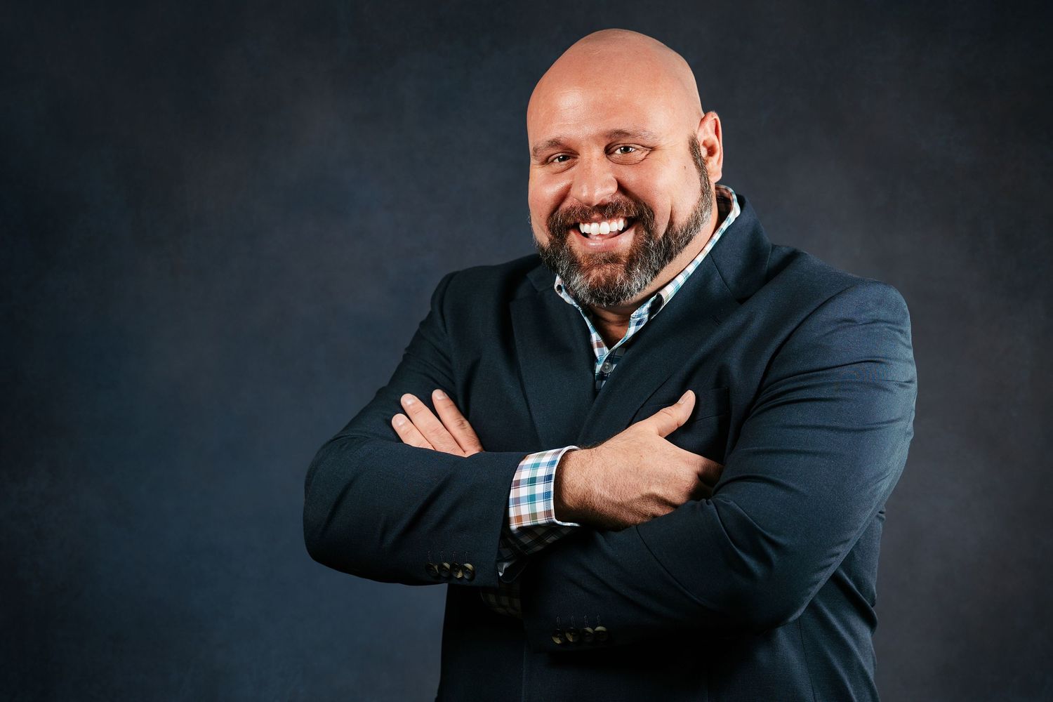 Professional headshot portraits of someone in business attire against dark background showing different expressions.