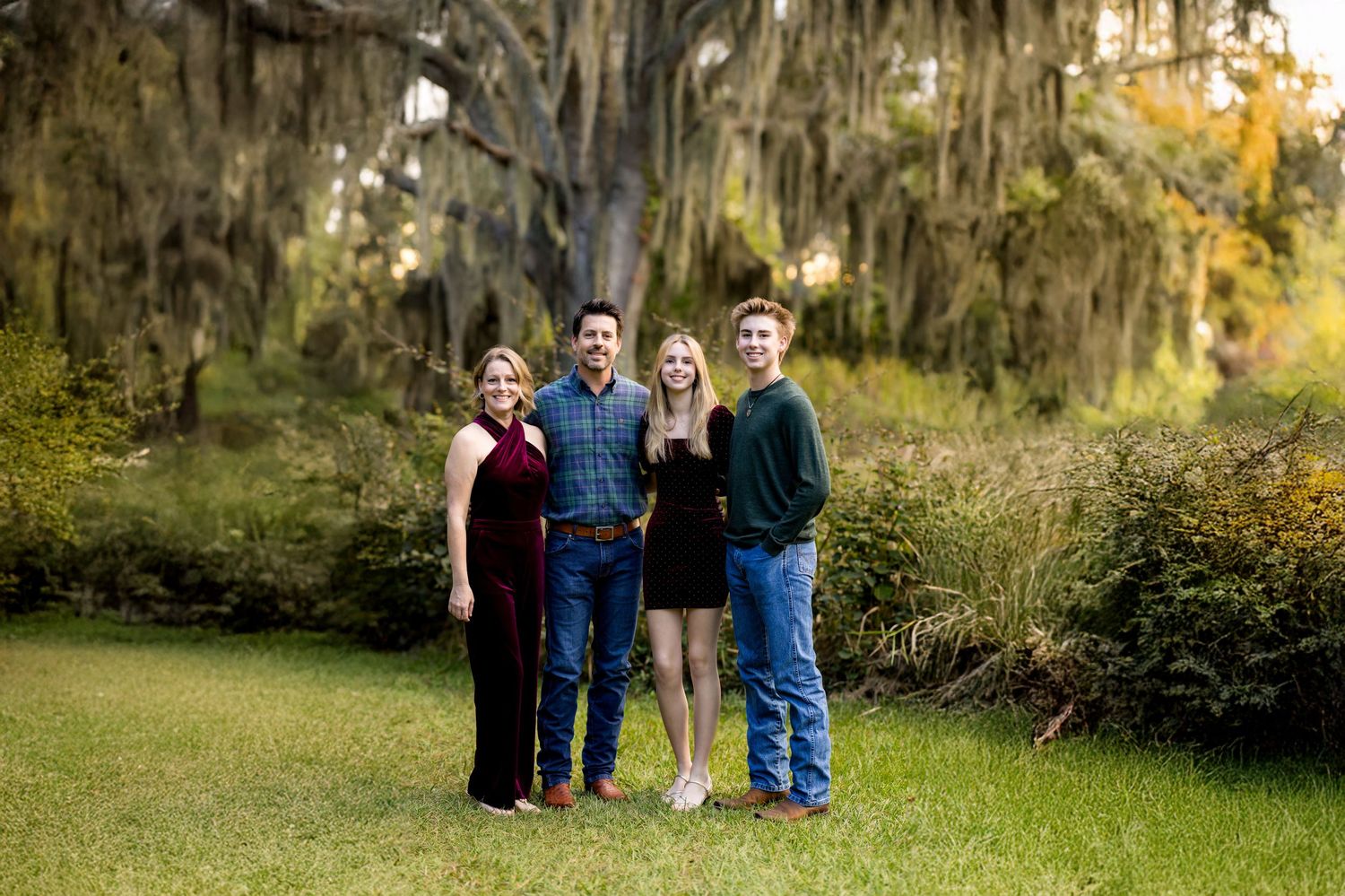 A series of outdoor family portrait photos taken in a natural setting with trees and autumn foliage.