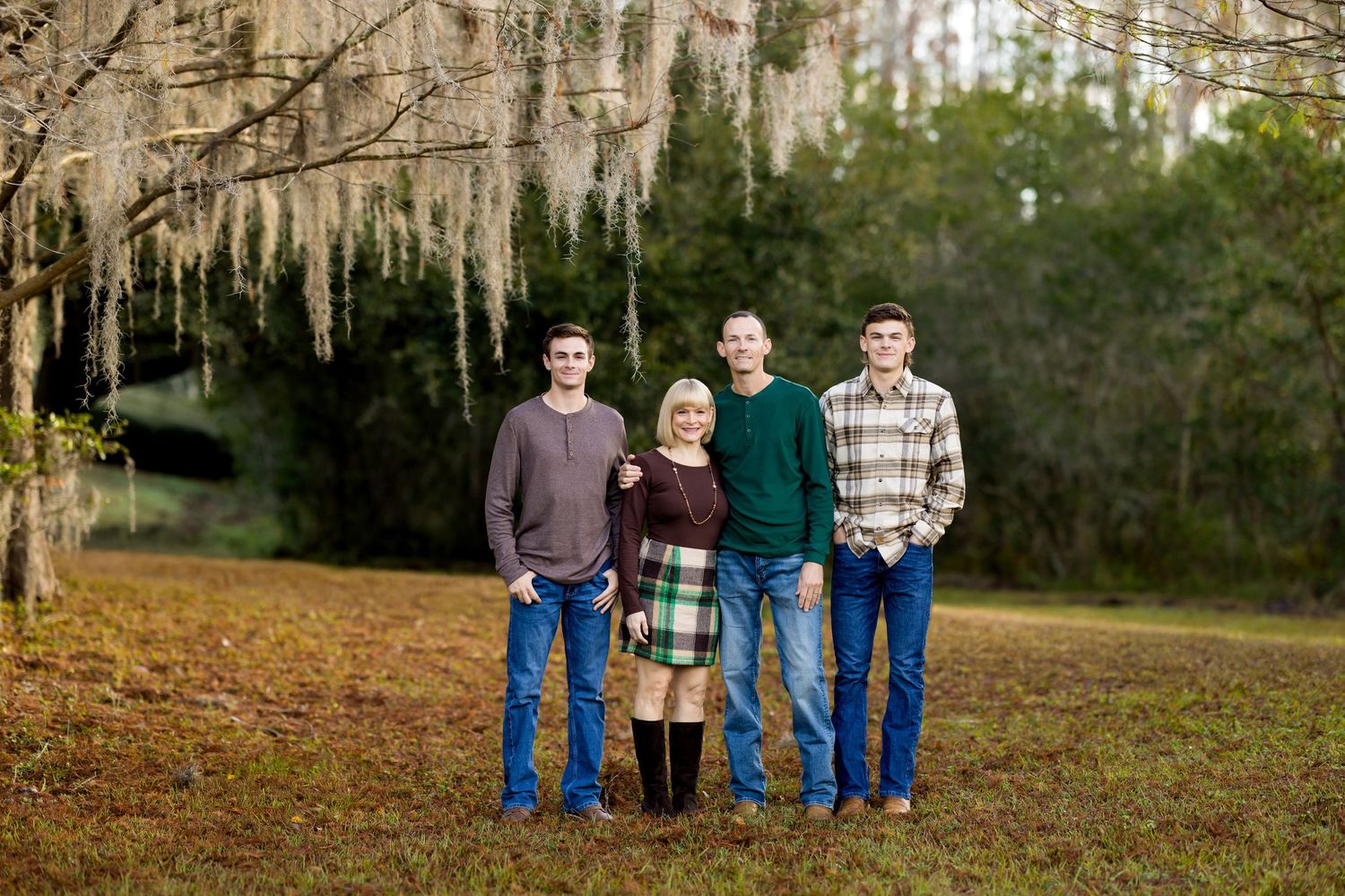 Family photo session captured in a series of outdoor portraits against a wooded natural background.