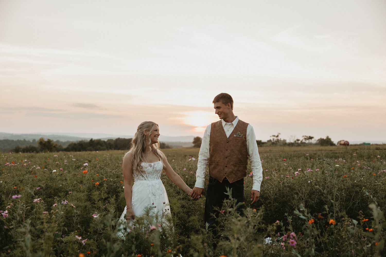 Wedding ceremony takes place under a rustic wooden pavilion with exposed beams and scenic view through archway in background.