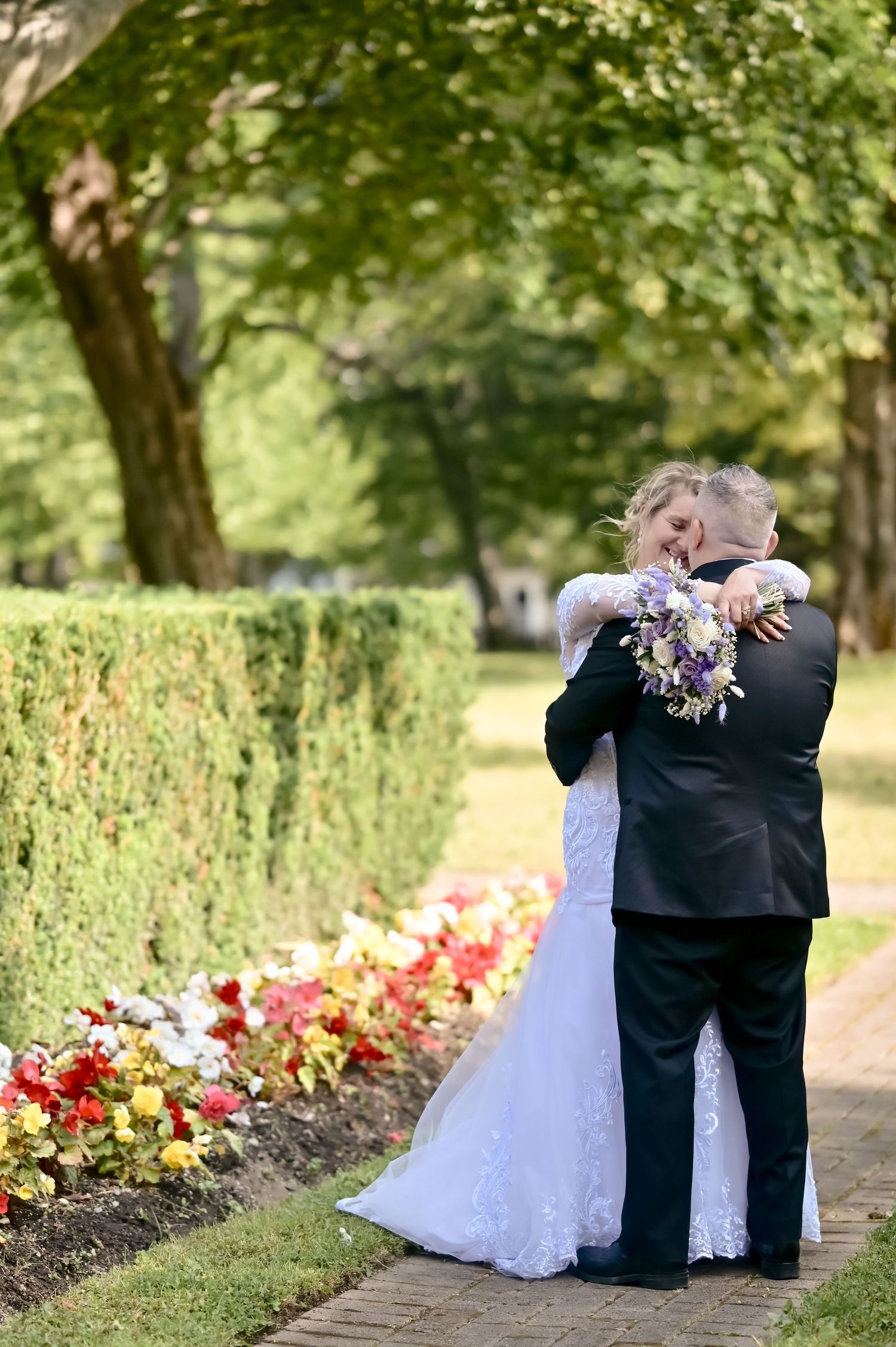 bride holding bouquet while embracing groom at Government House, St. John's Newfoundland wedding photography