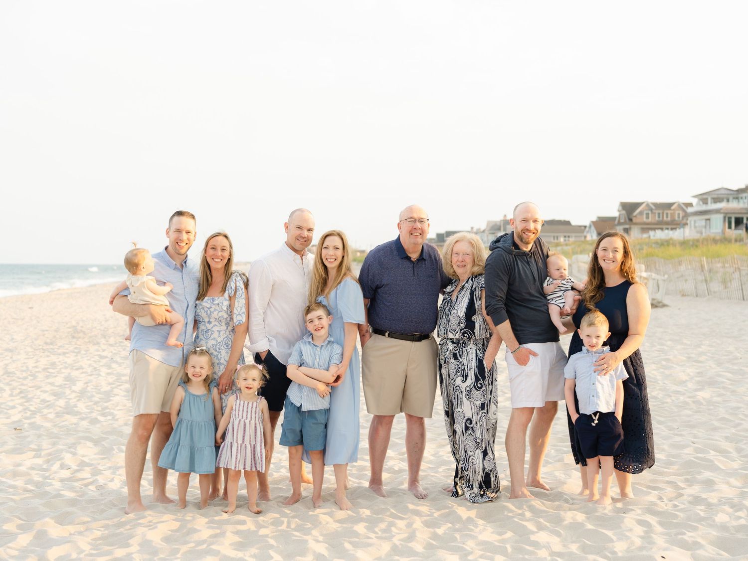 Laid-back extended family laughing together on the sand at Mantoloking Beach, NJ.