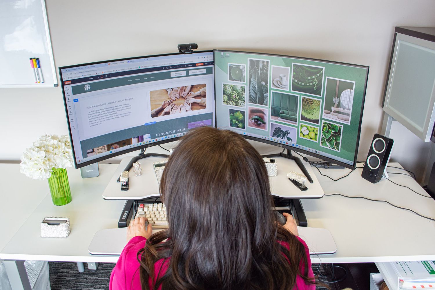 A office woman entrepaneur working in her brightly lit high key office with designer materials featuring her brand with photography