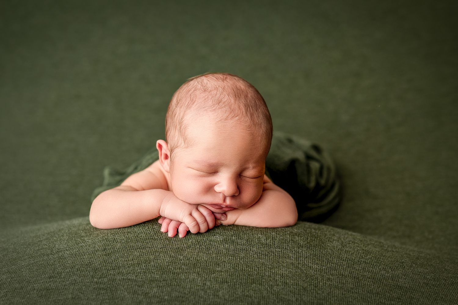 A series of artistic newborn baby photos showing peaceful sleeping poses on a dark green textured backdrop.