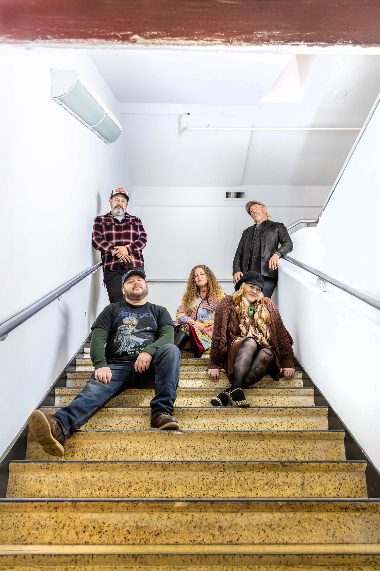 A band sits in a stairwell with a strong and confident energy.