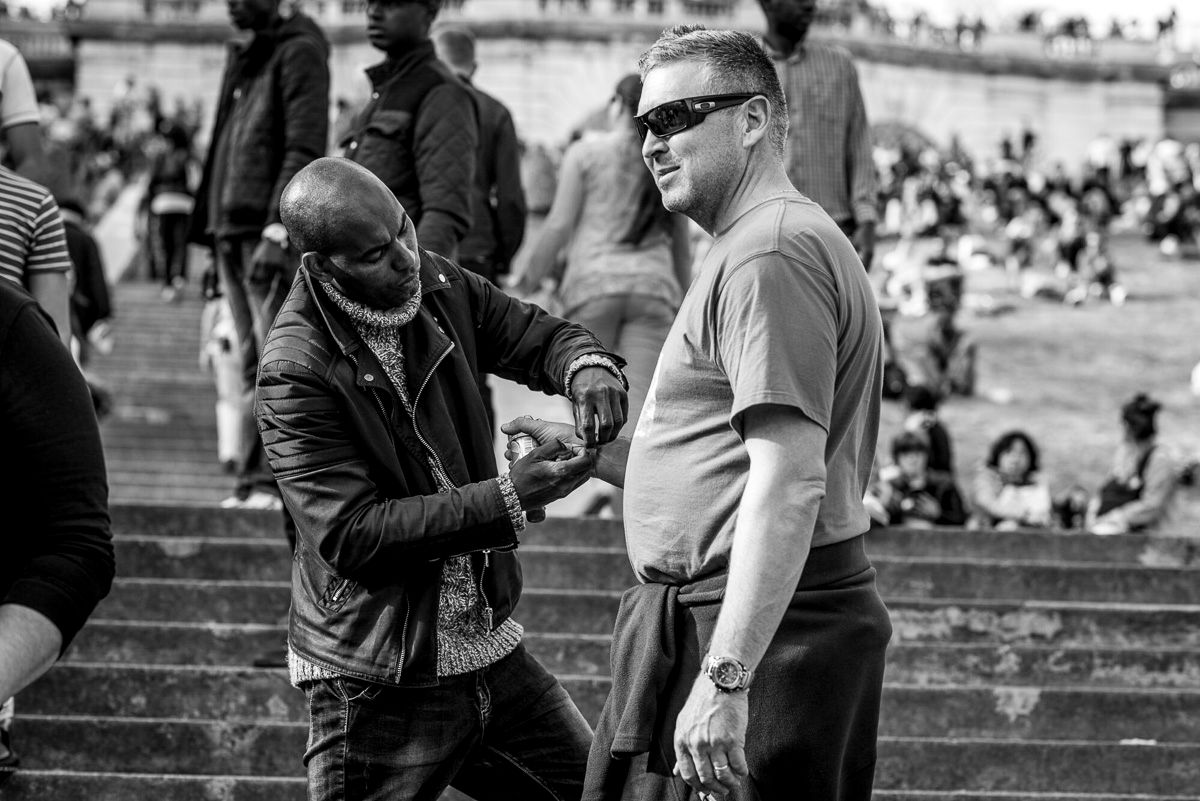 Black and white candid shot of people conversing on the steps of Montmartre.