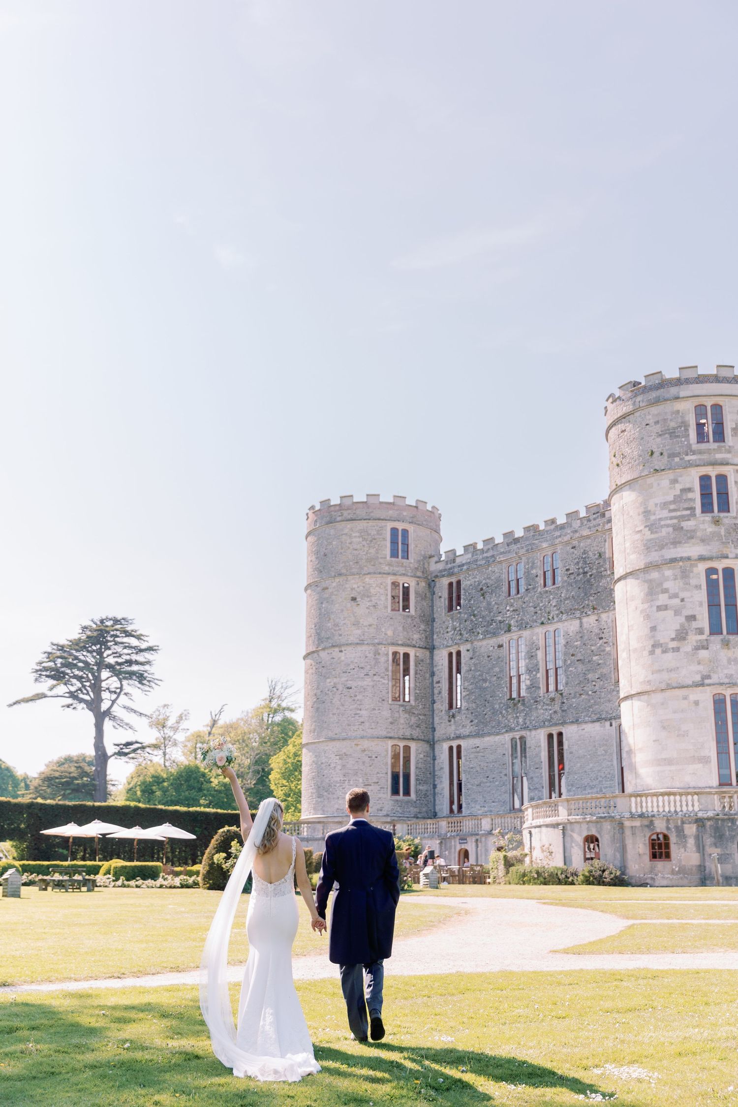 Couple walks up to Lulworth Castle in Dorset, photographed by Maddie Waters Dorset wedding photographer
