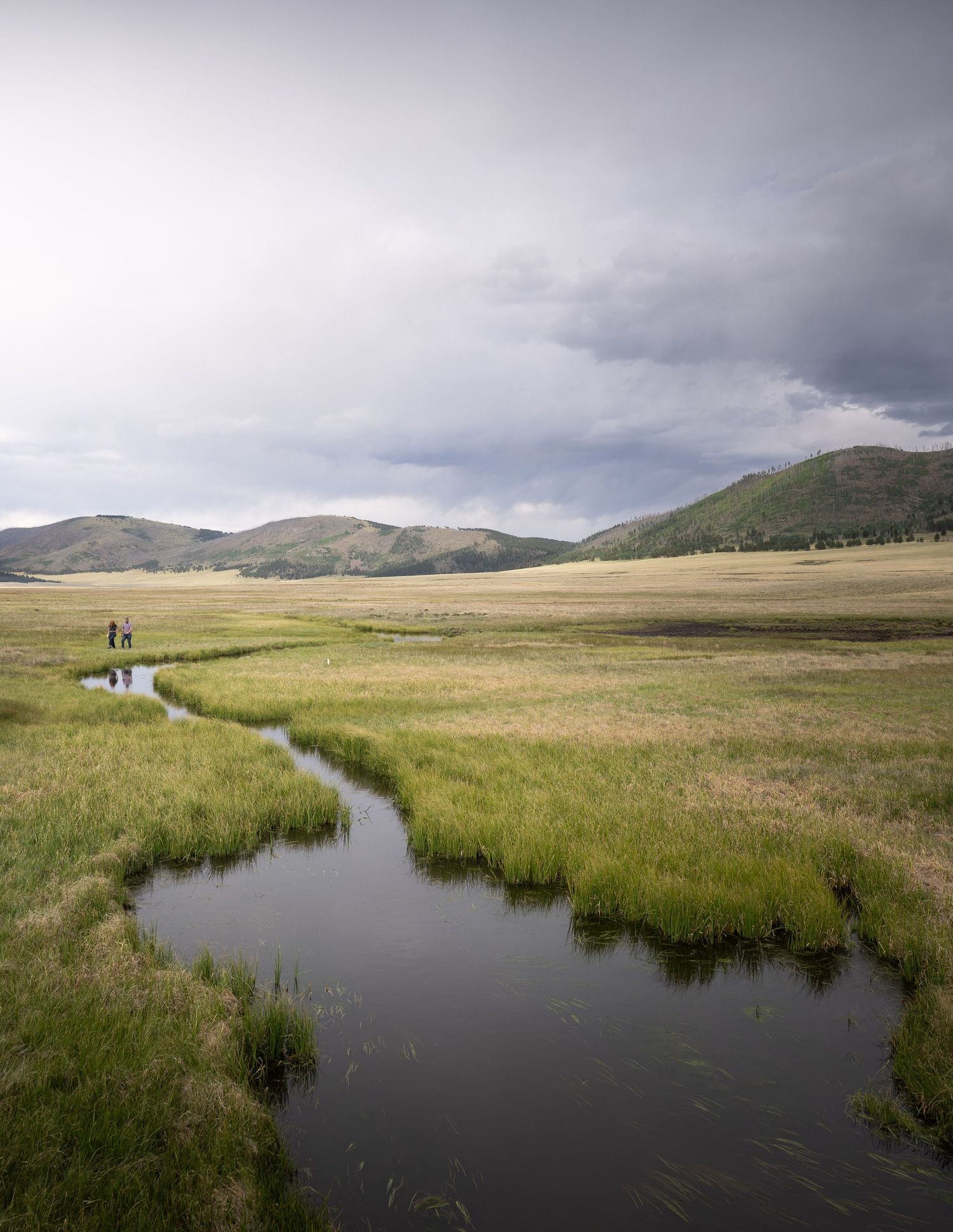 A couple strolls along the creek at Valles Caldera National Preserve, New Mexico.