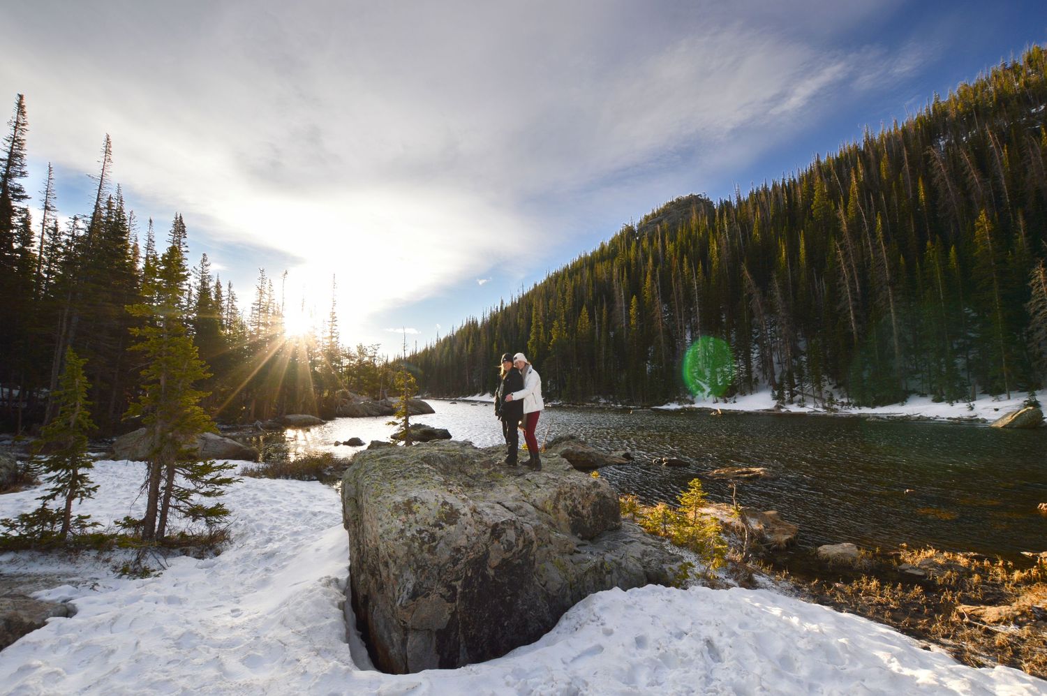 Couple posing on a rock next to Dream Lake after she said yes to her proposal. Pixcapades | The Rocky Mountain Proposal Photographer