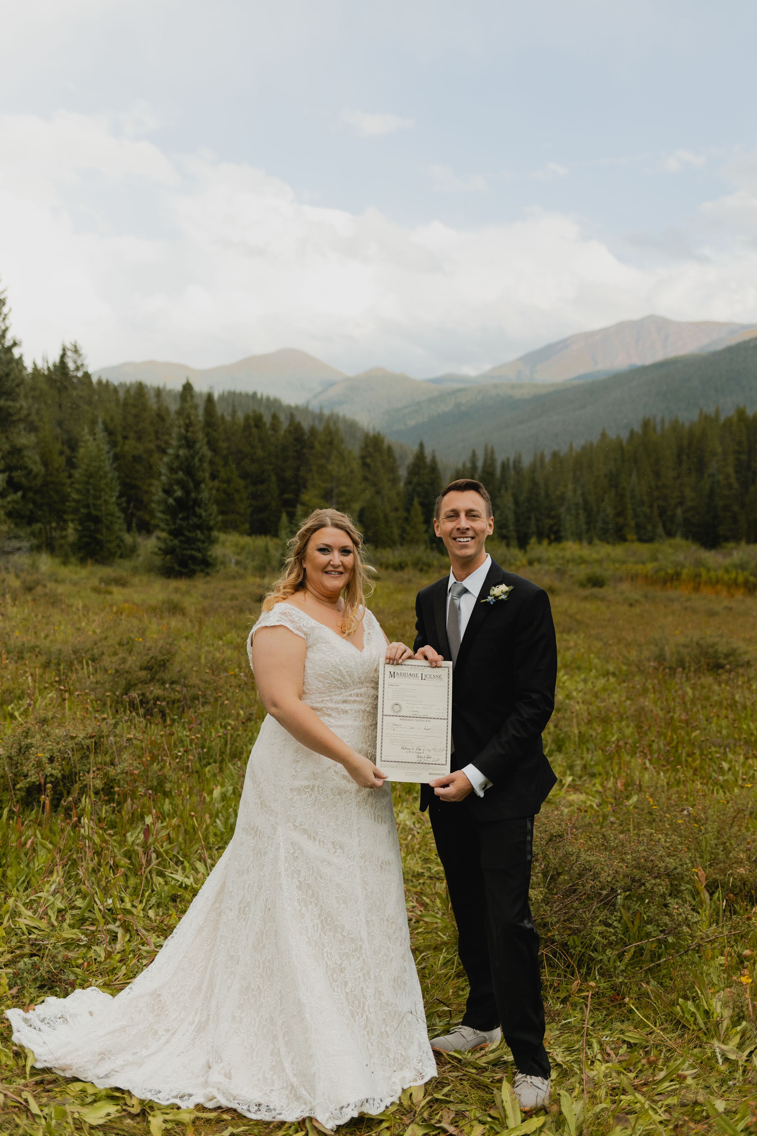 Bride and groom share a tender moment amidst Breckenridge's majestic peaks.