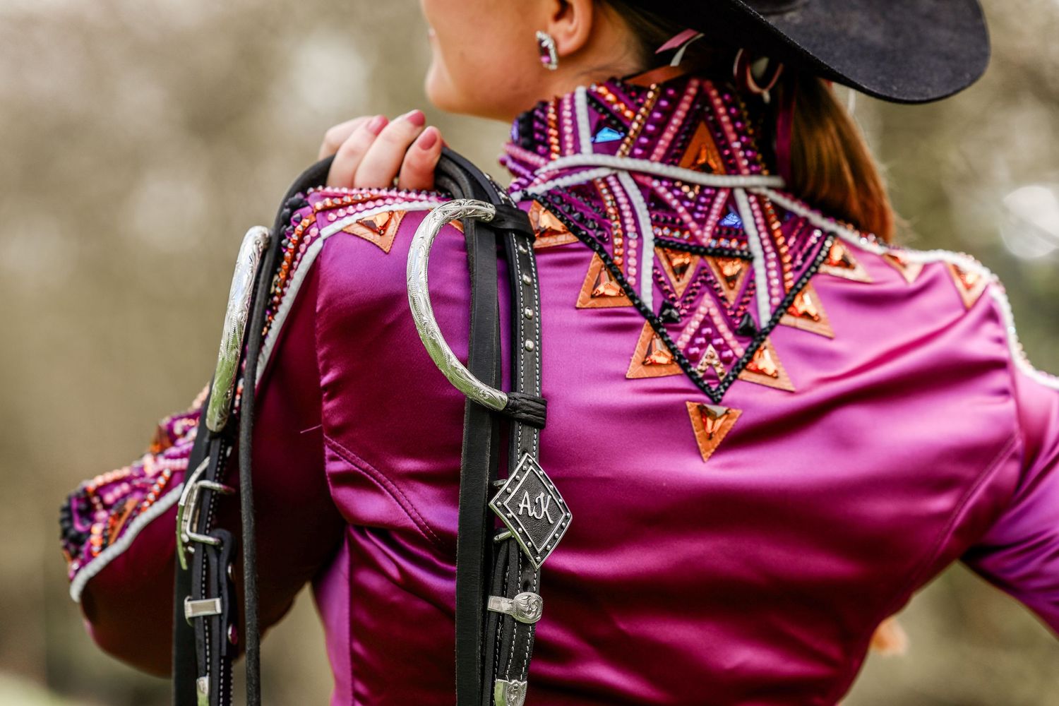 Pink western show jacket with decorative geometric beading pattern on back.