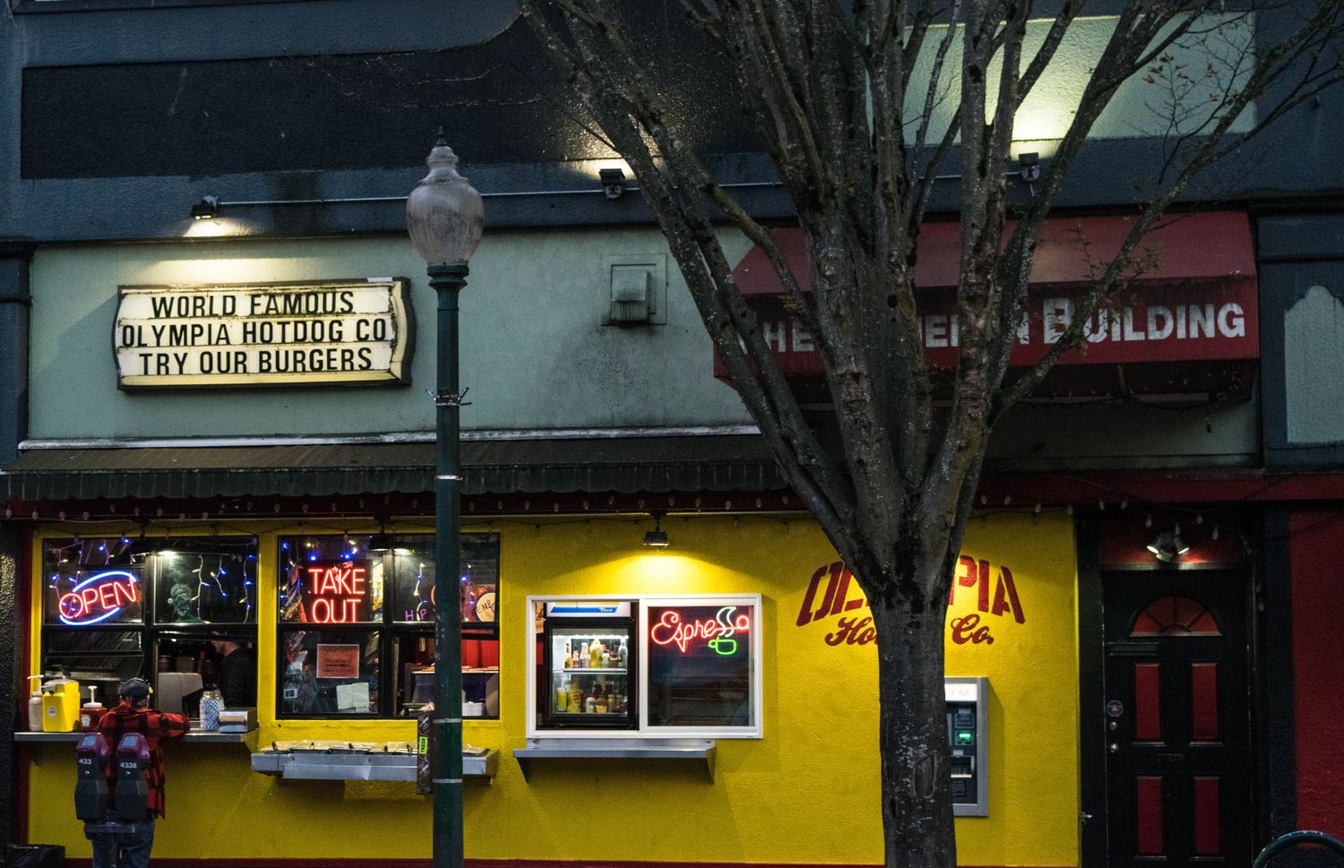 Yellow storefront with retro signage and windows lit up at night.