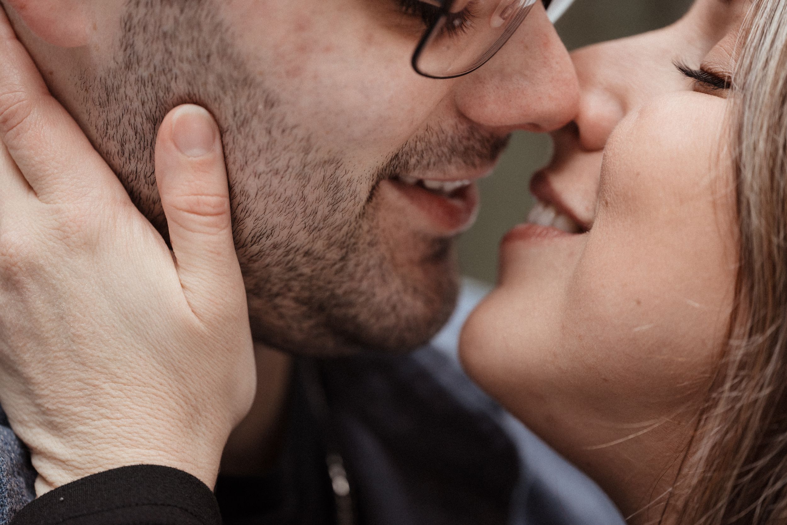 A romantic close-up of a couple about to kiss in warm natural lighting.