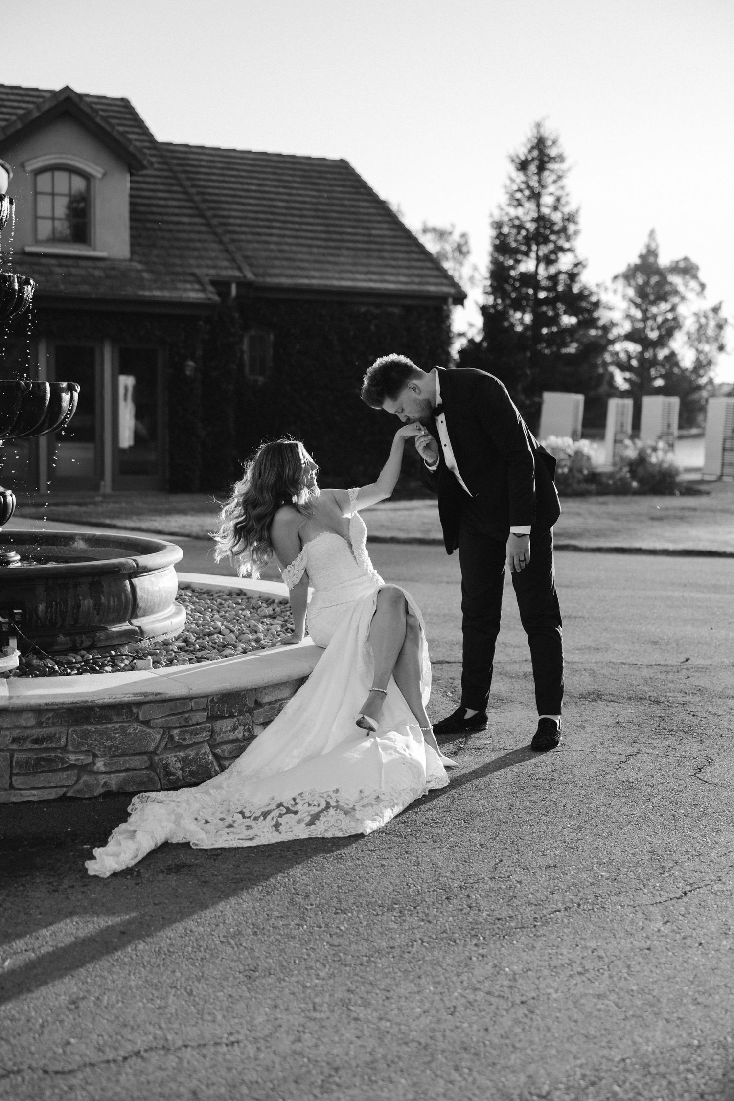 An intimate black and white wedding moment captured by a stone fountain.