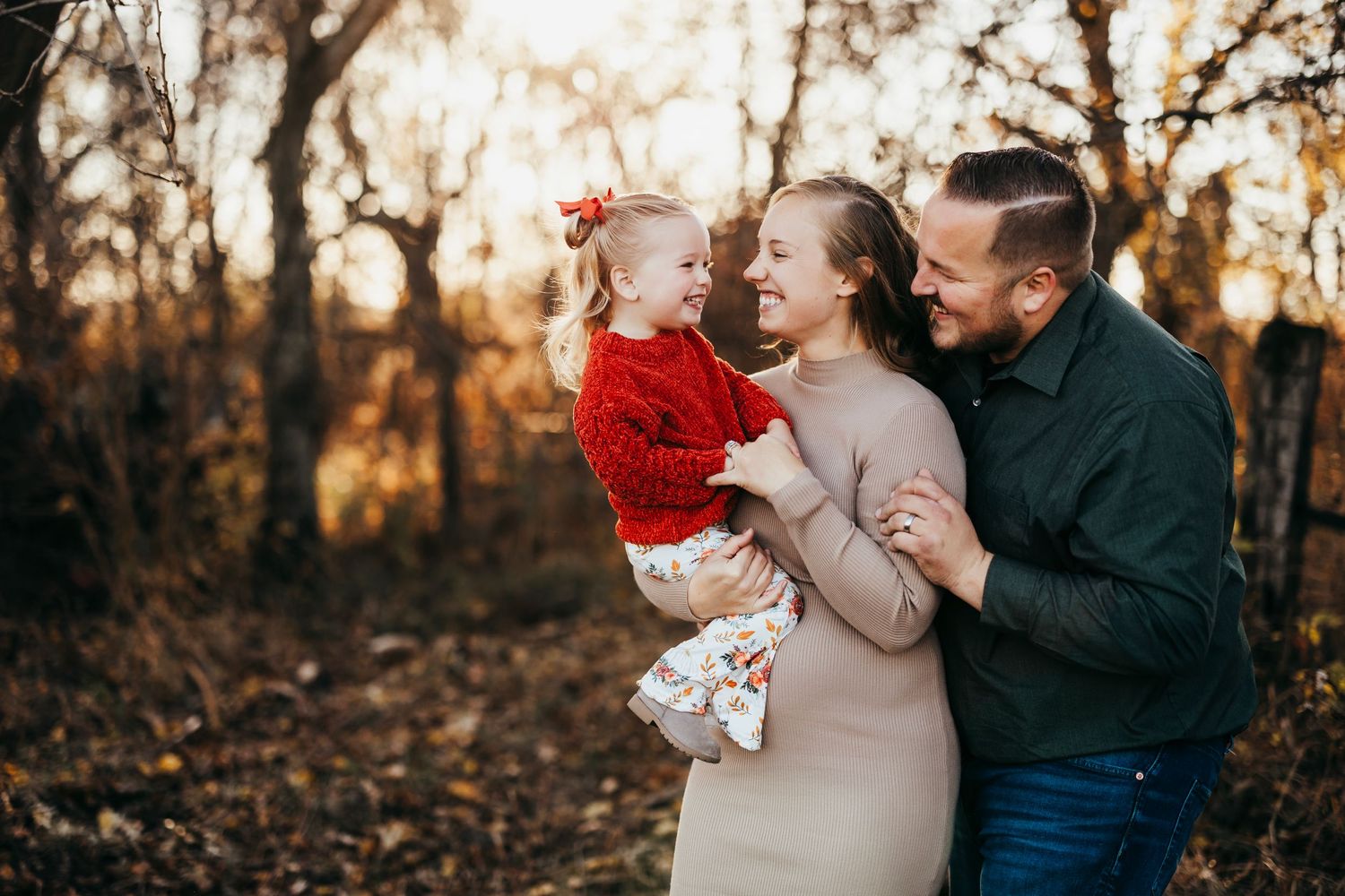 Family shares joyful moment together outdoors during golden hour autumn photoshoot.