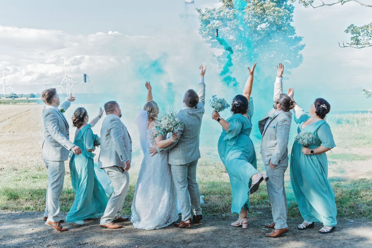 Row of people in coordinated turquoise and white outfits sitting together outdoors. Photographer. Hull. East Yorkshire. Photography