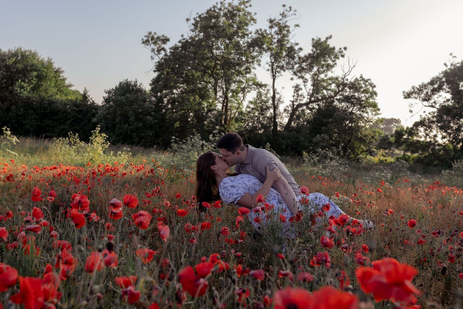 Couple sharing intimate moment in field of red poppies during sunset. Photographer. Hull. East Yorkshire. Photography