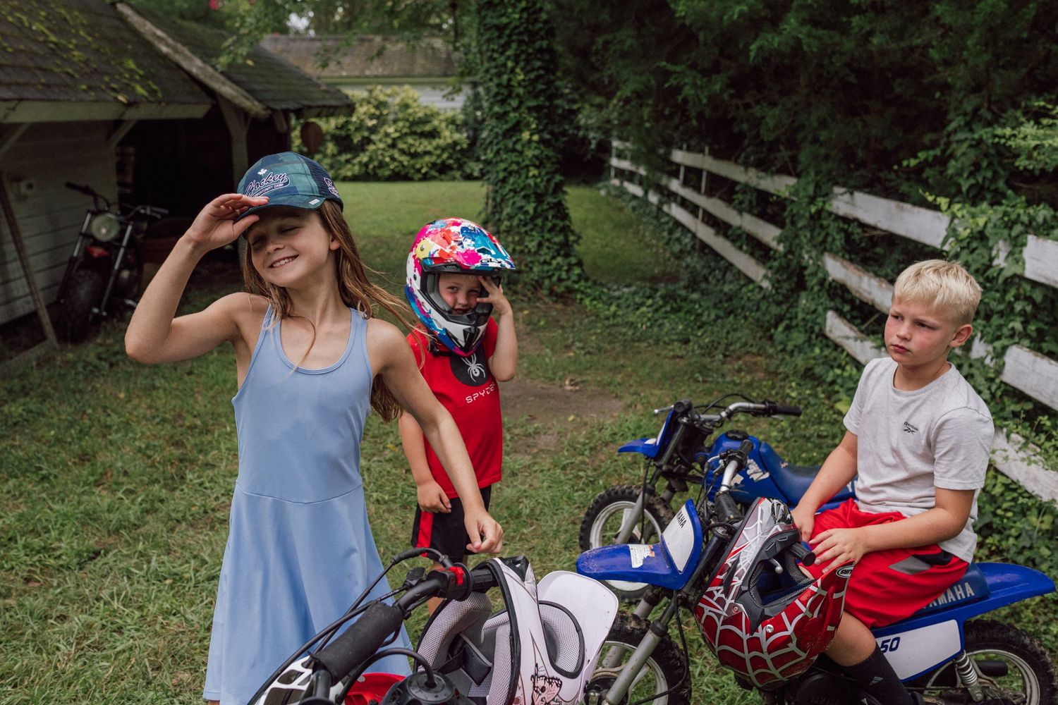 Young rider wearing protective gear on a dirt bike in a shaded outdoor setting. eastern shore virginia family photography