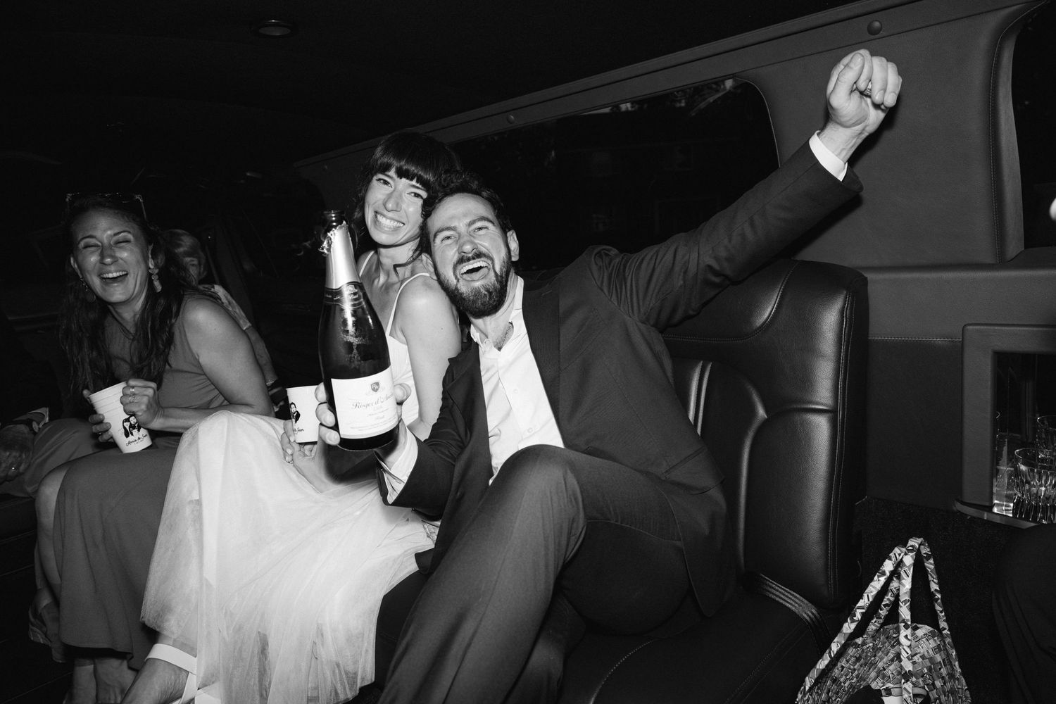 Wedding guests dancing and celebrating on the dance floor at a reception in black and white.