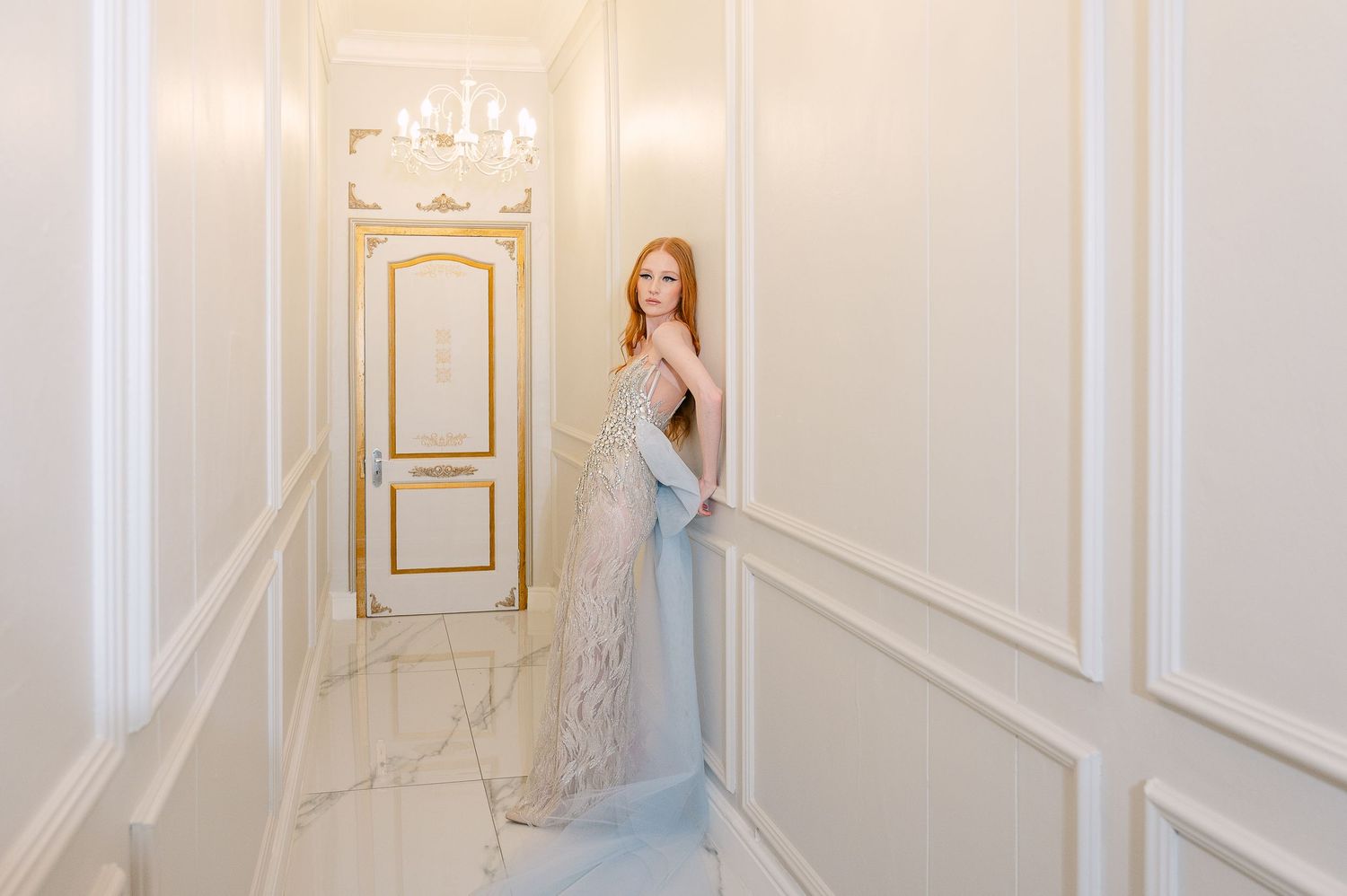 A stunning embellished wedding dress with intricate beading and ethereal design photographed in an elegant white setting.
