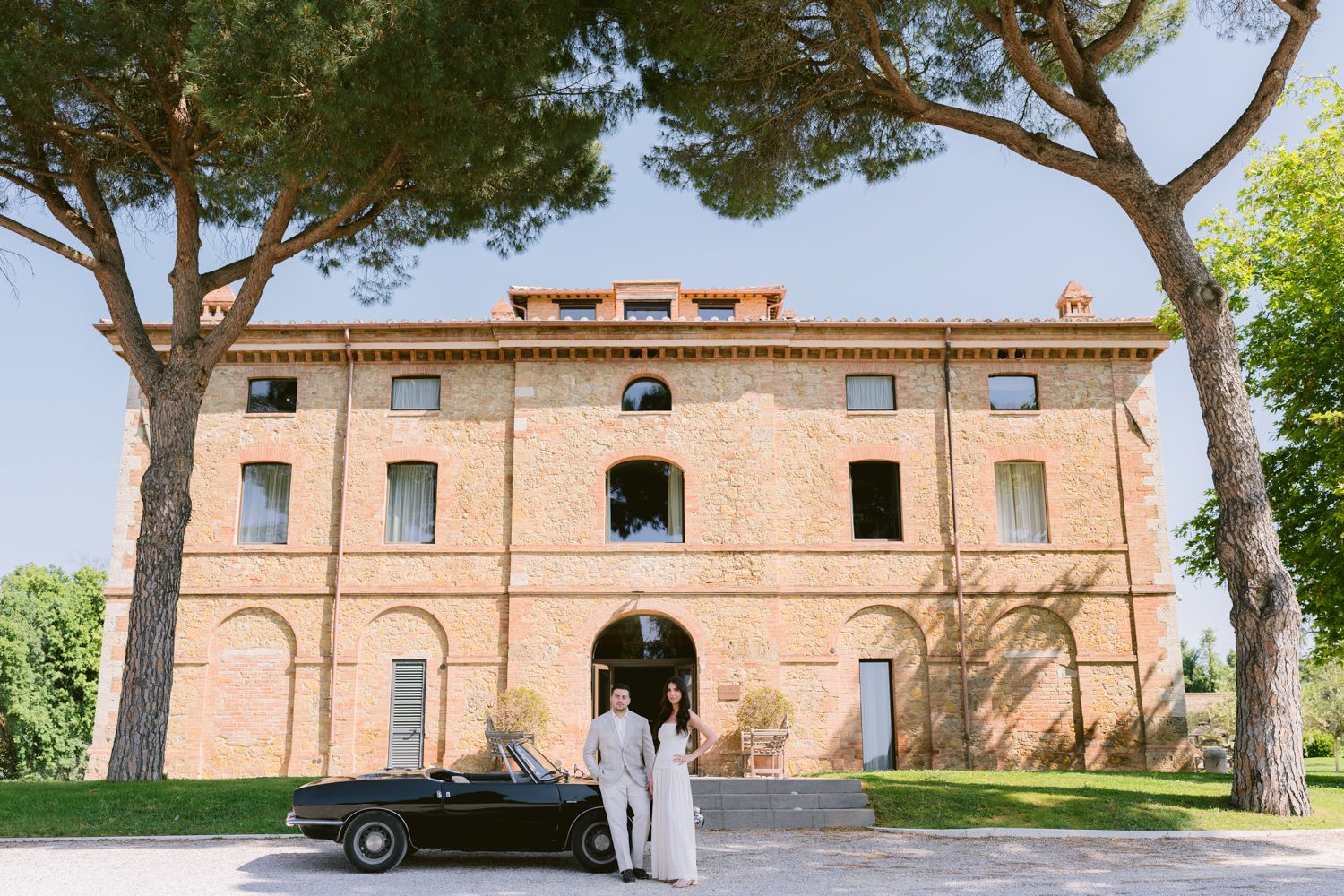 Rolling hills and scenic countryside views of Tuscany with cypress trees and rustic buildings dotting the landscape.