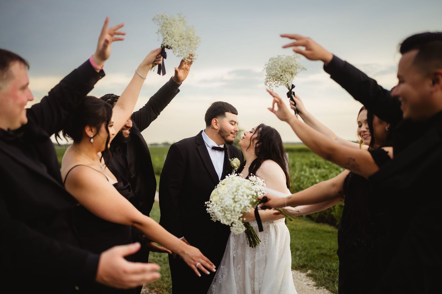 Wedding celebration at night with string lights and white folding chairs in a rustic venue setting.