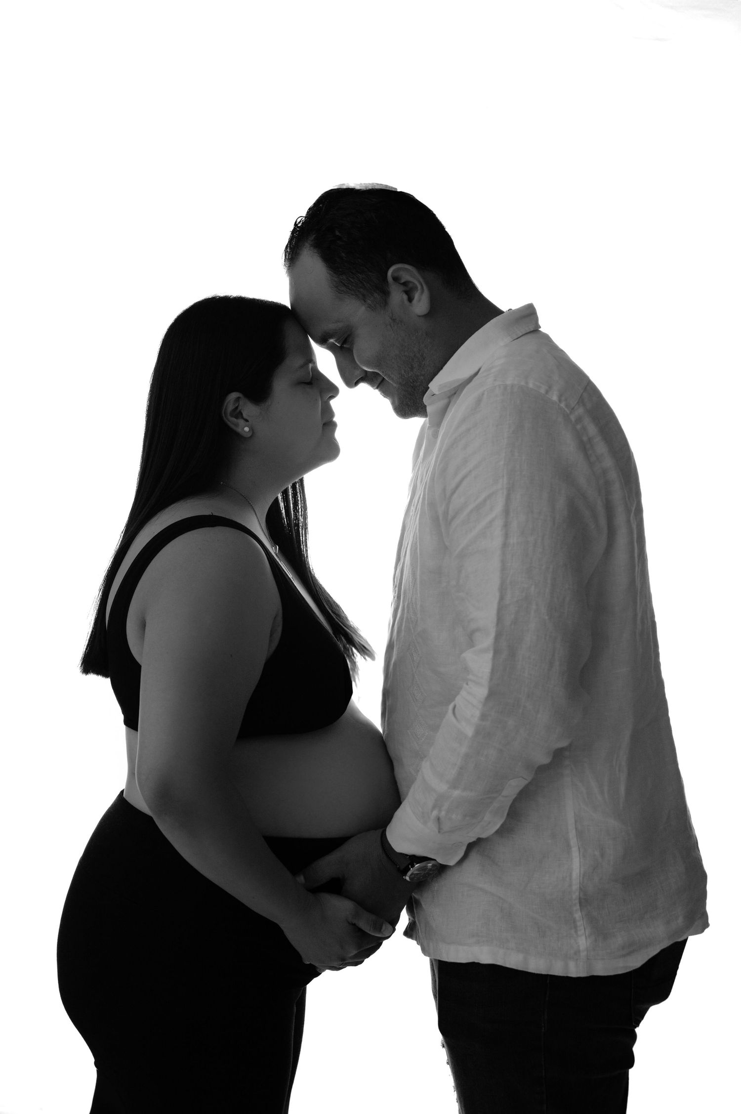 Three black and white silhouettes show a couple in an intimate moment against a white background.