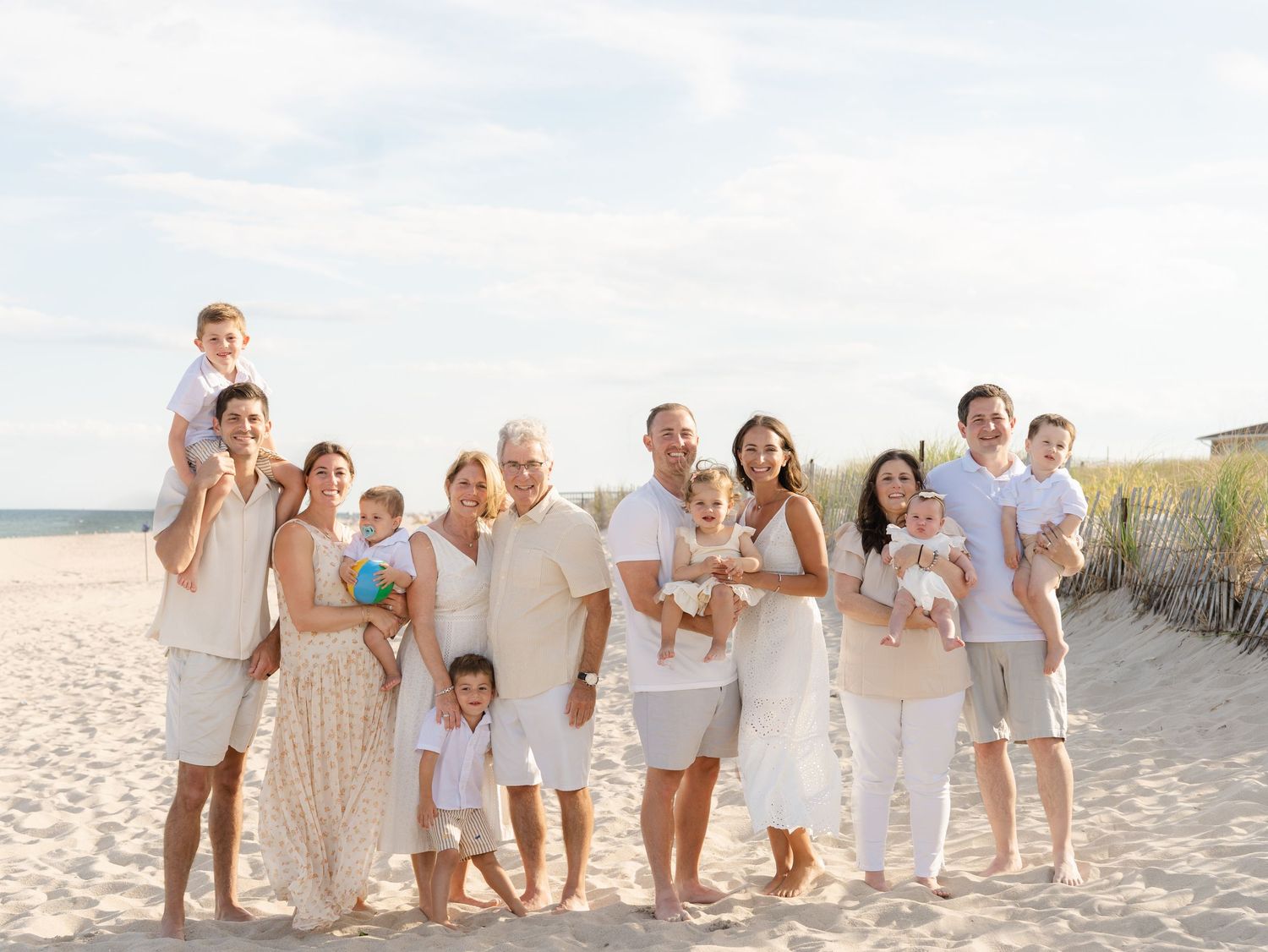 Extended multi-generational family standing together on Point Pleasant Beach at golden hour.