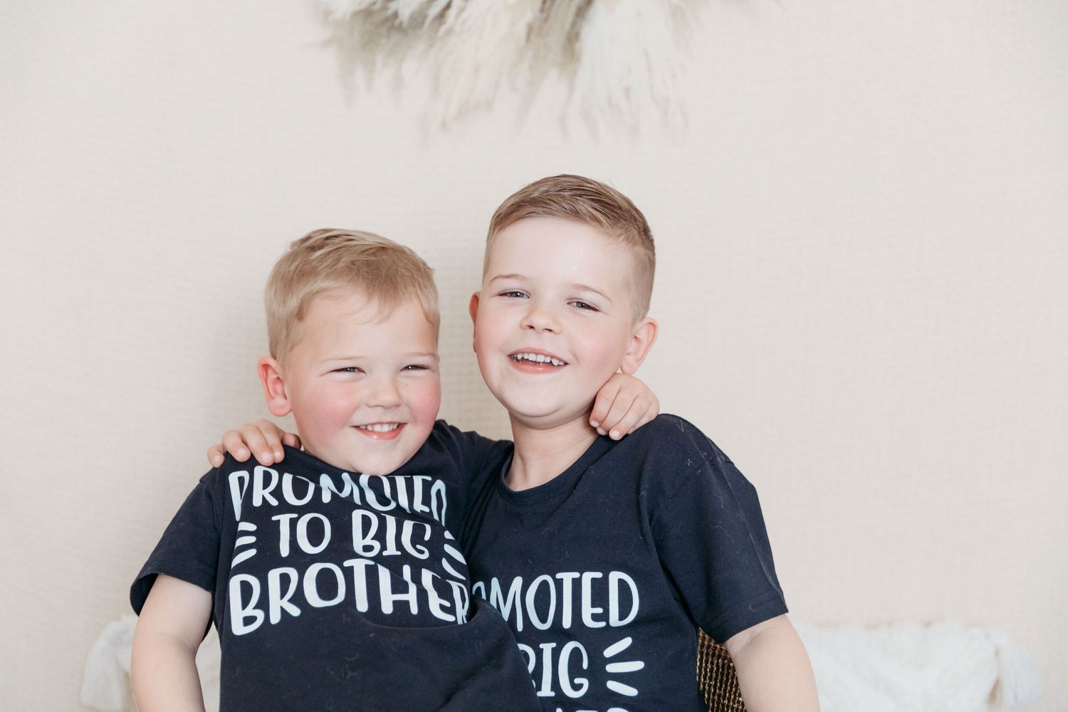 Two children wearing matching black t-shirts with sibling text sitting together. Photographer. Hull. East Yorkshire. Photography
