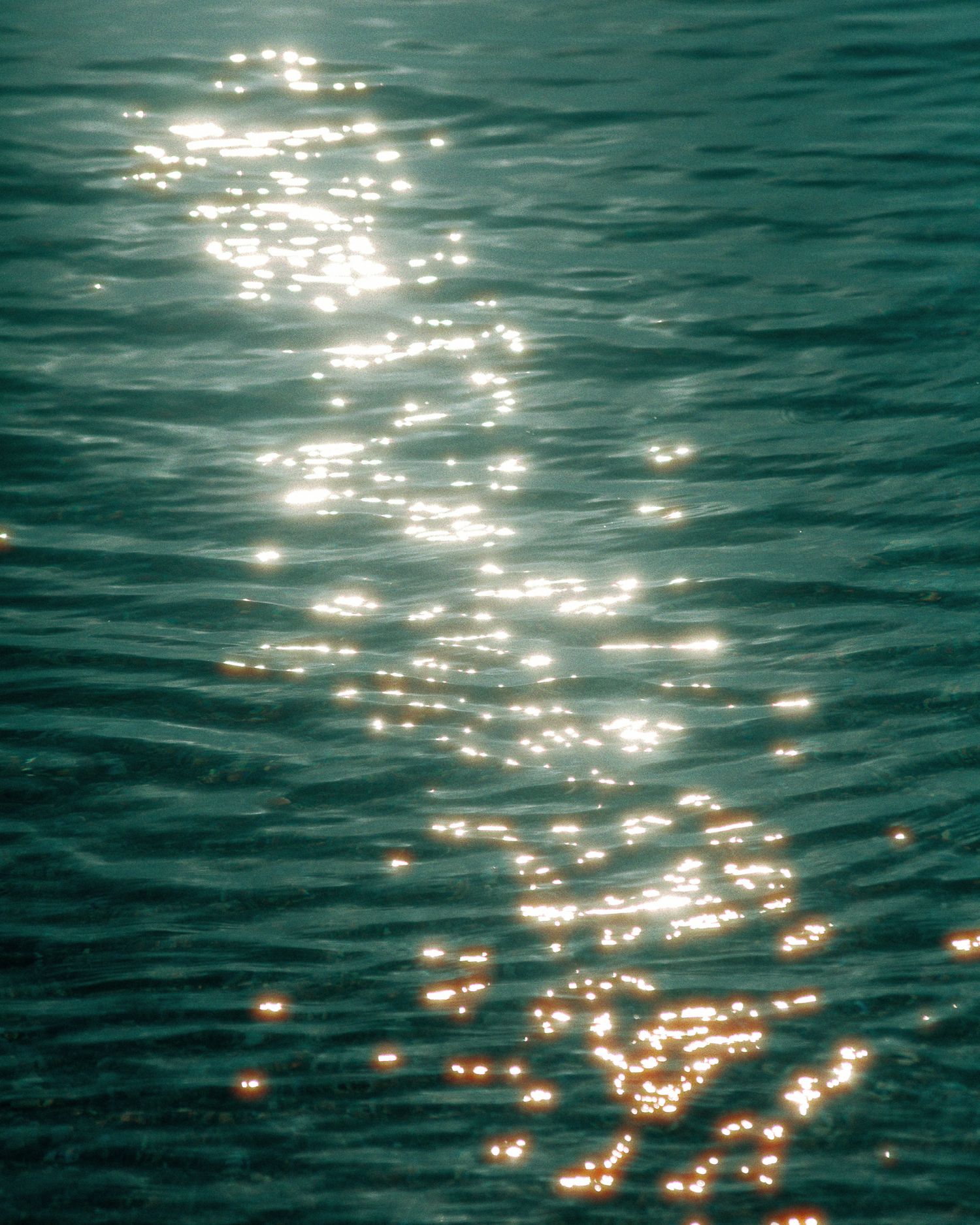 Sunlight reflecting on gentle sea ripples, photographed close-up.