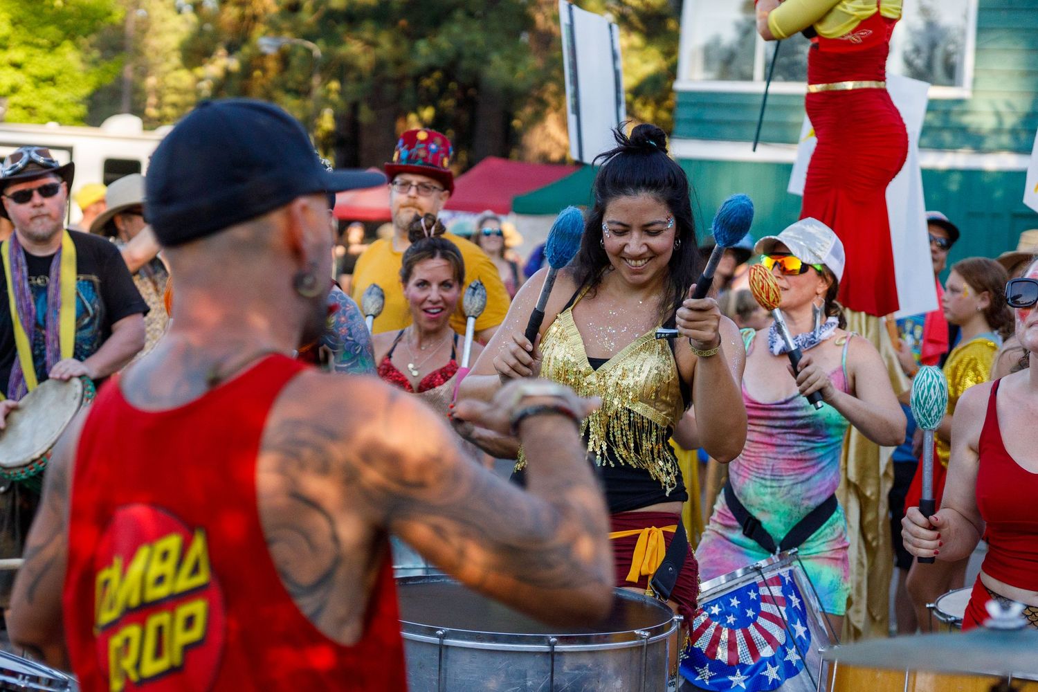 Festival attendees dancing and celebrating in bright summer clothing.