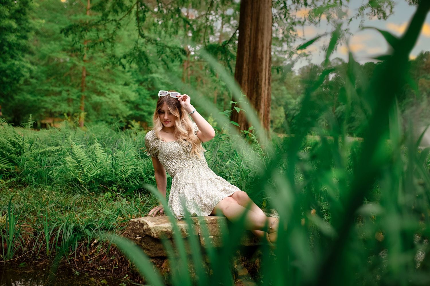 Dreamy forest portrait session with vintage dress and lush green foliage.