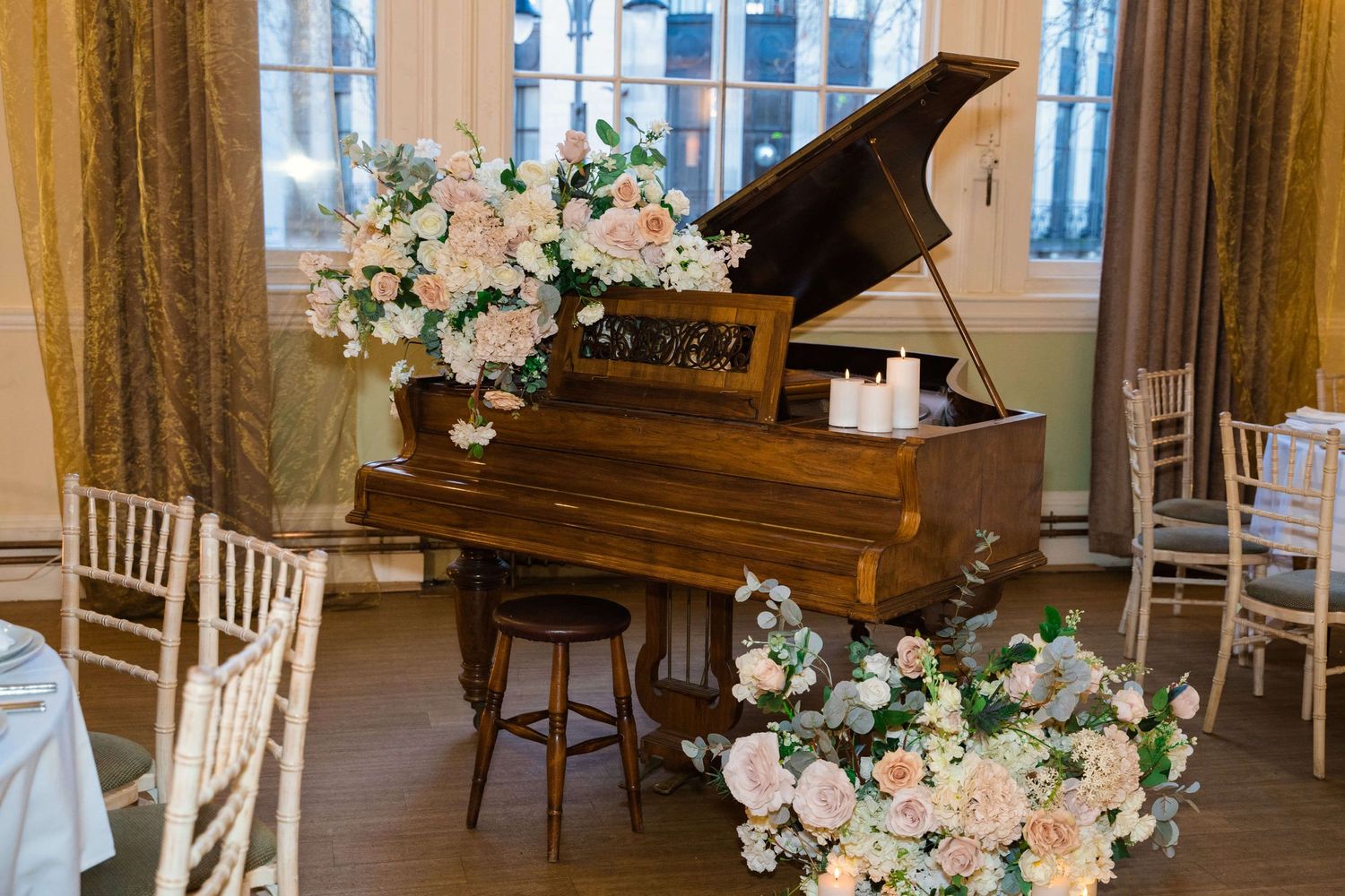 Wedding decorations and a grand piano in the room.