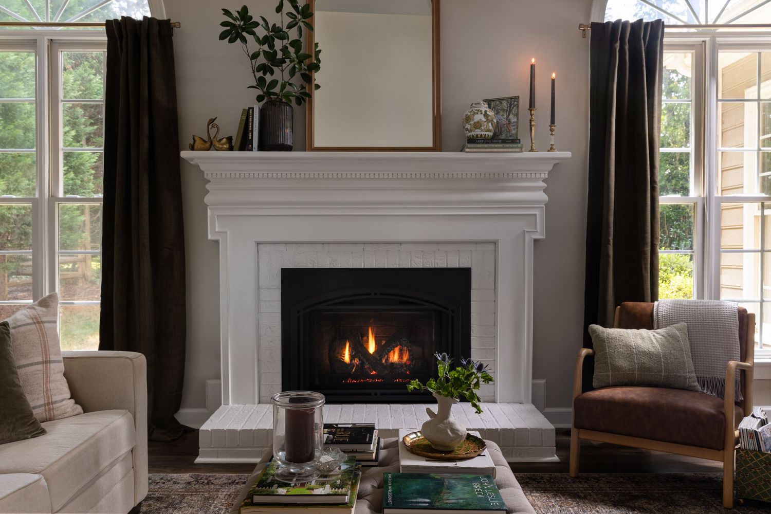 Elegant living room with white fireplace mantel, comfortable seating, and French doors.