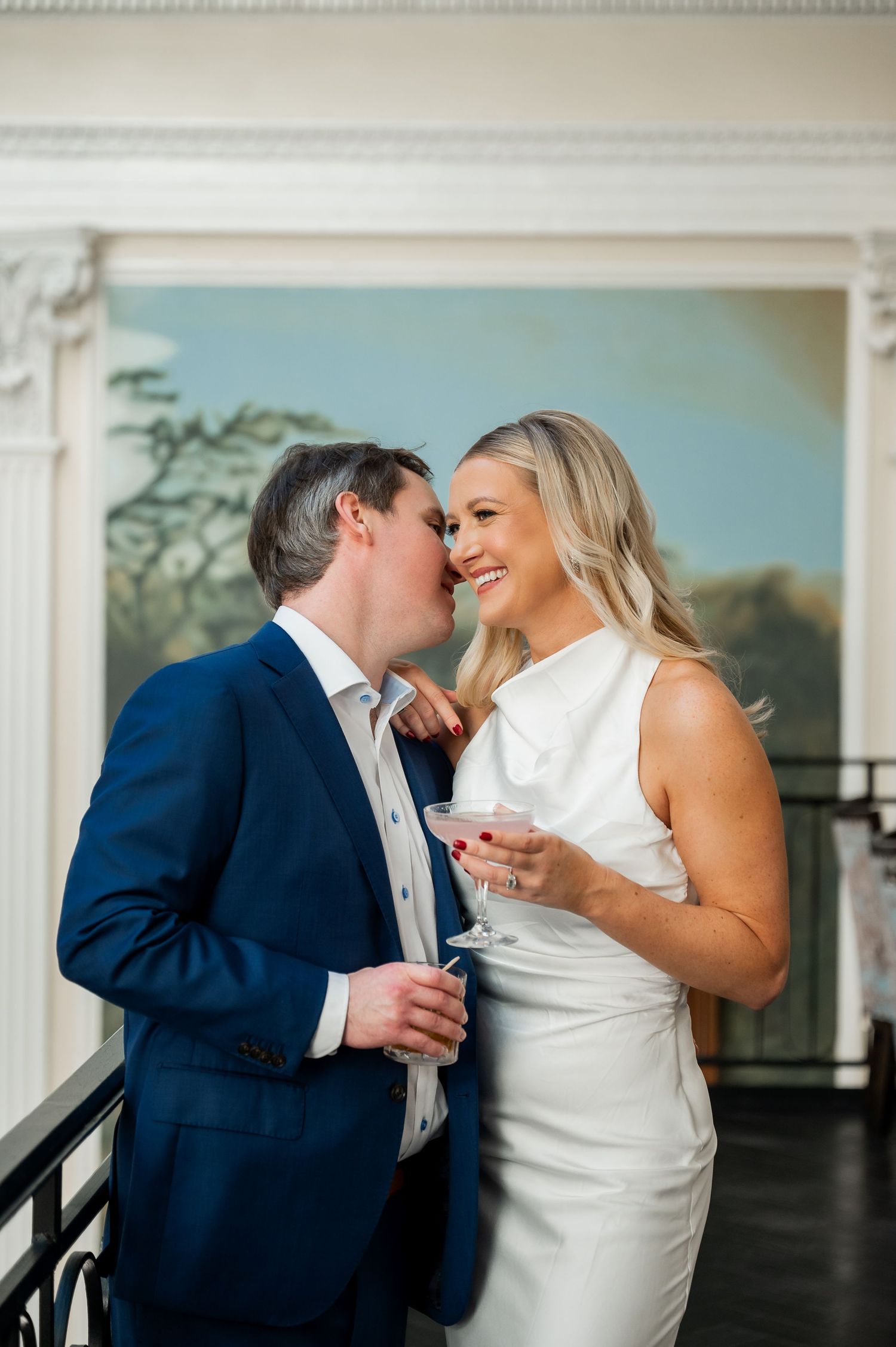 Romantic moment captured at an elegant venue with ornate white molding.